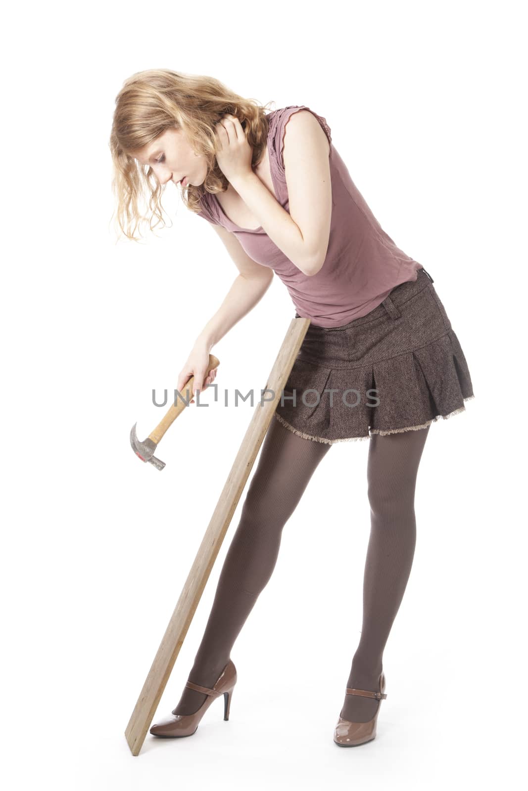 young pretty woman with hammer and wood against white background