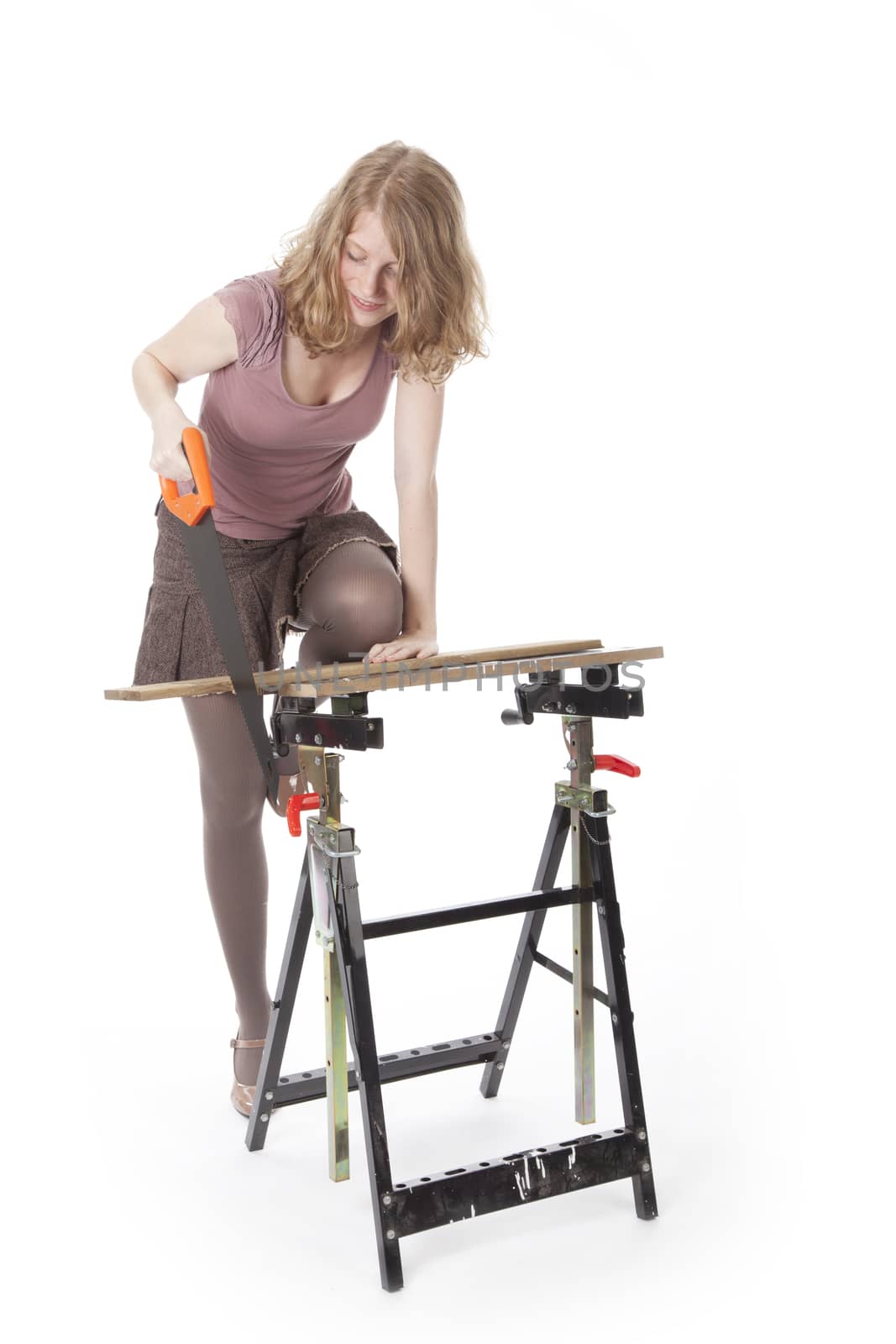 young woman sawing wood with hand saw