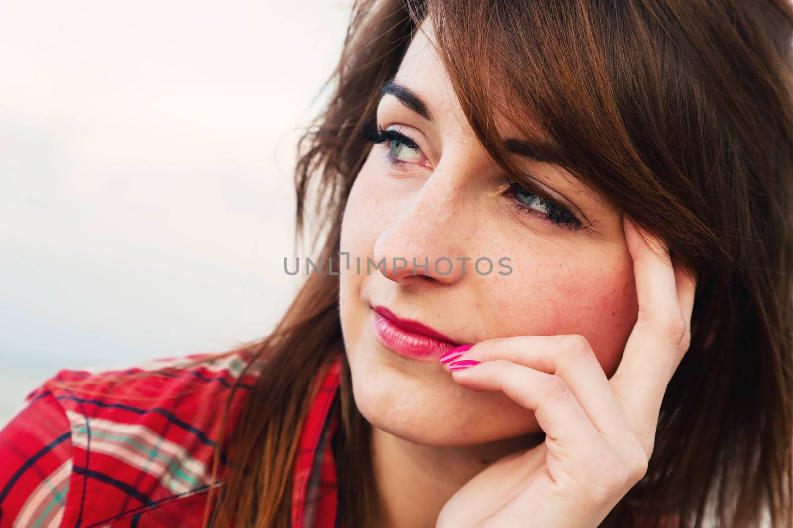 Pretty young woman looking at the ocean in a romantic way by photocreo