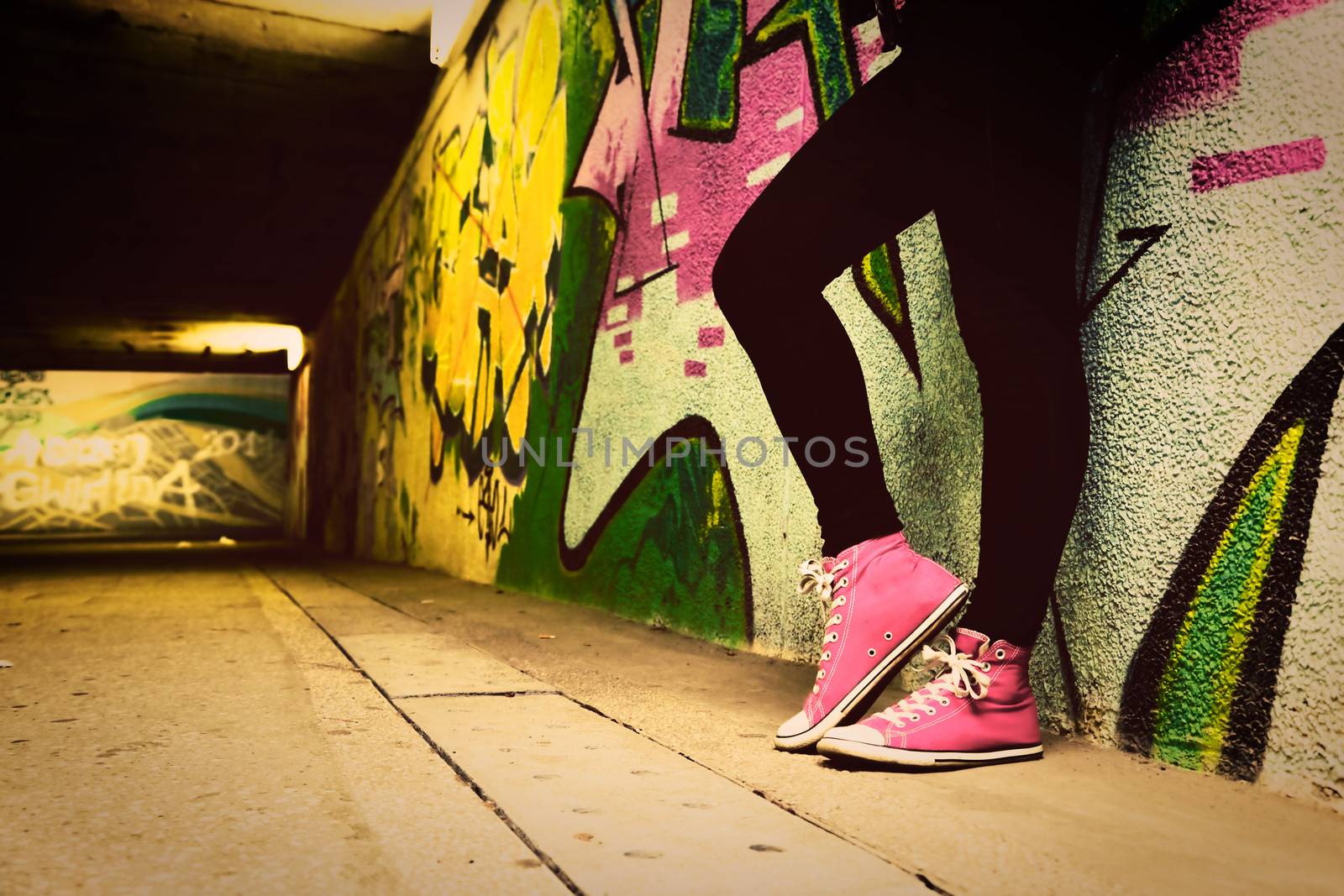 Close up of pink sneakers worn by a teenager. by photocreo