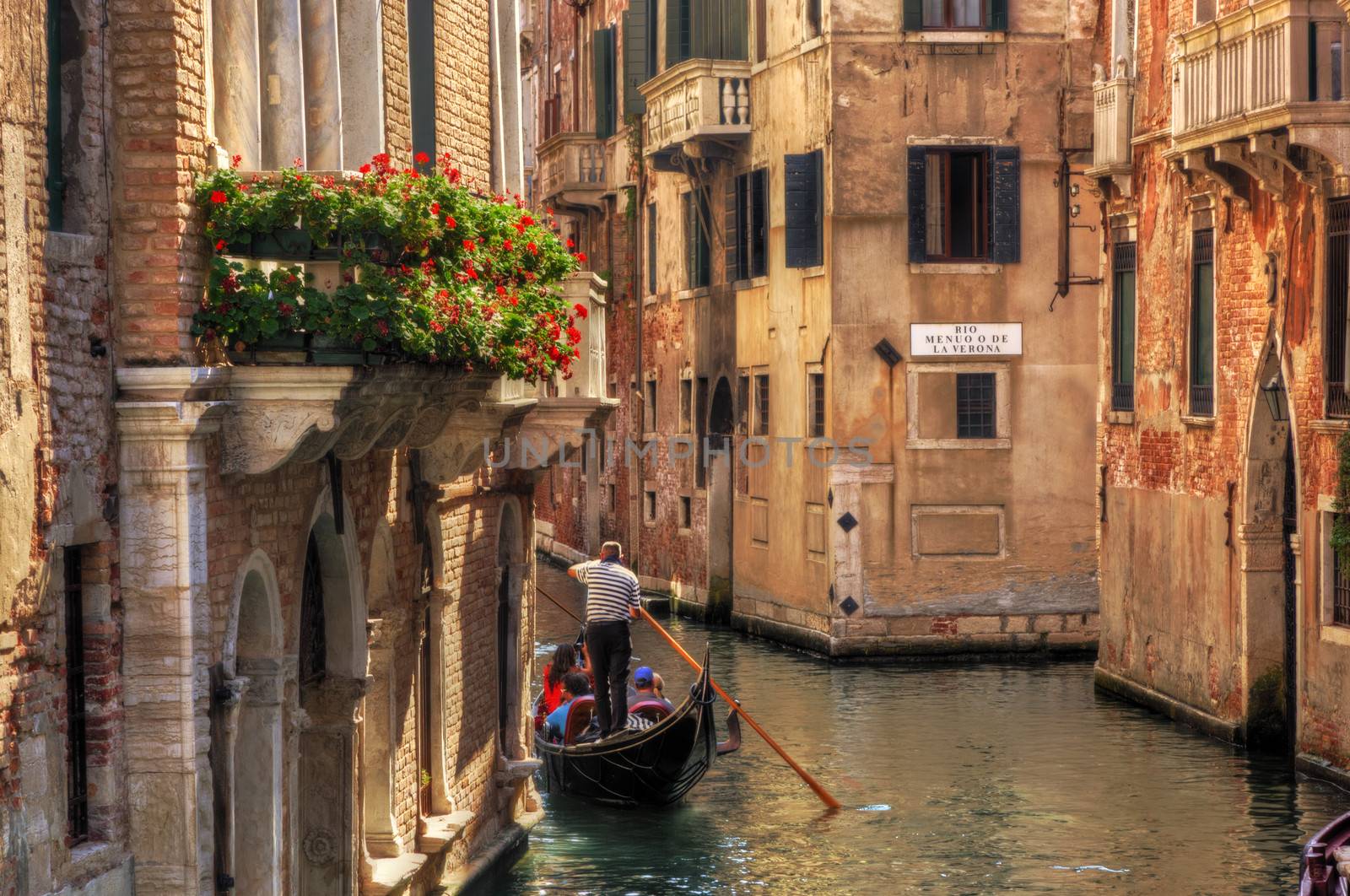 Venice, Italy. Gondola floats on a canal among old Venetian architecture by photocreo