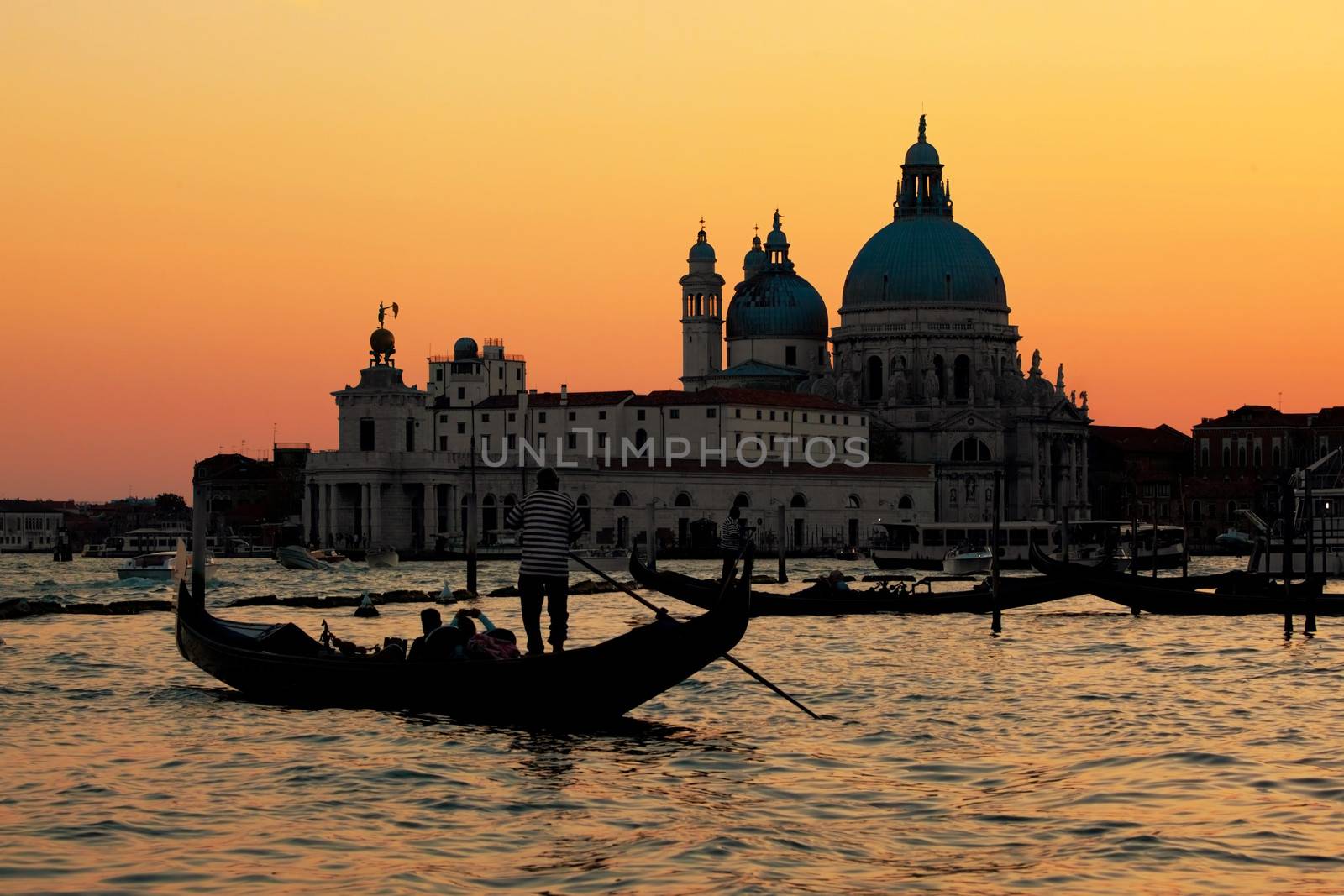 Venice, Italy. Gondola on Grand Canal at sunset. Basilica Santa Maria della Salute in the background