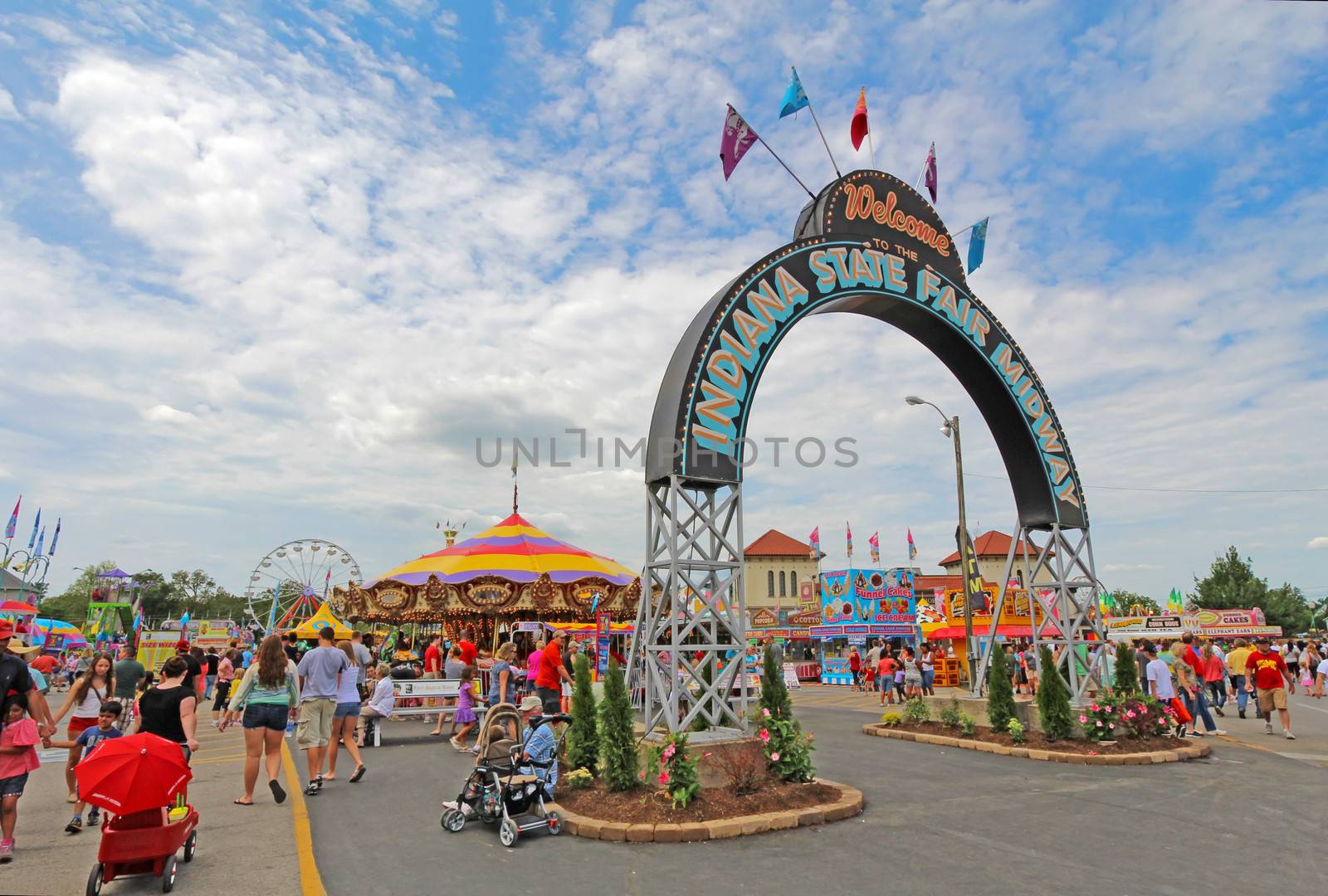 INDIANAPOLIS, INDIANA - AUGUST 12: Fairgoers at the main entrance to the Midway of the Indiana State Fair on August 12, 2012. This very popular fair hosts more than 850,000 people every August.