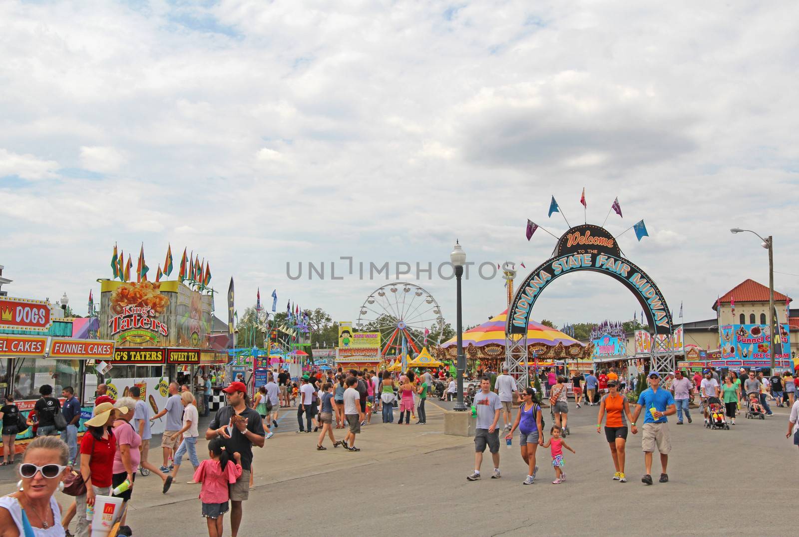 INDIANAPOLIS, INDIANA - AUGUST 12: Fairgoers at the main entrance to the Midway of the Indiana State Fair on August 12, 2012. This very popular fair hosts more than 850,000 people every August.