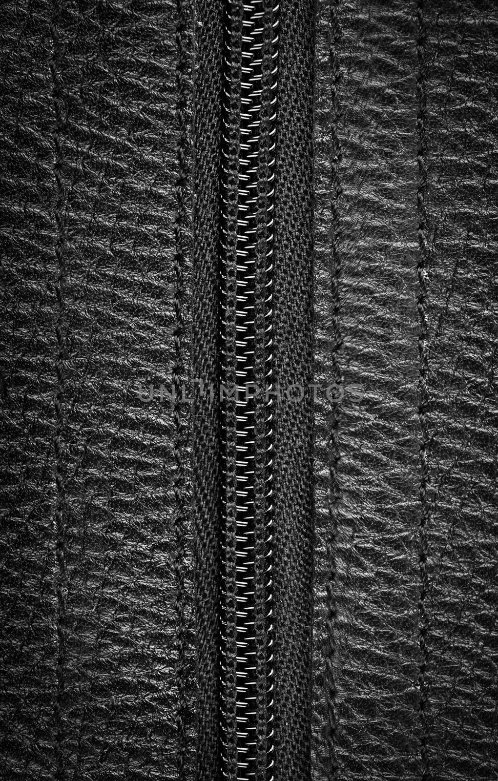 Close-up view of a closed zipper on a black leather bag