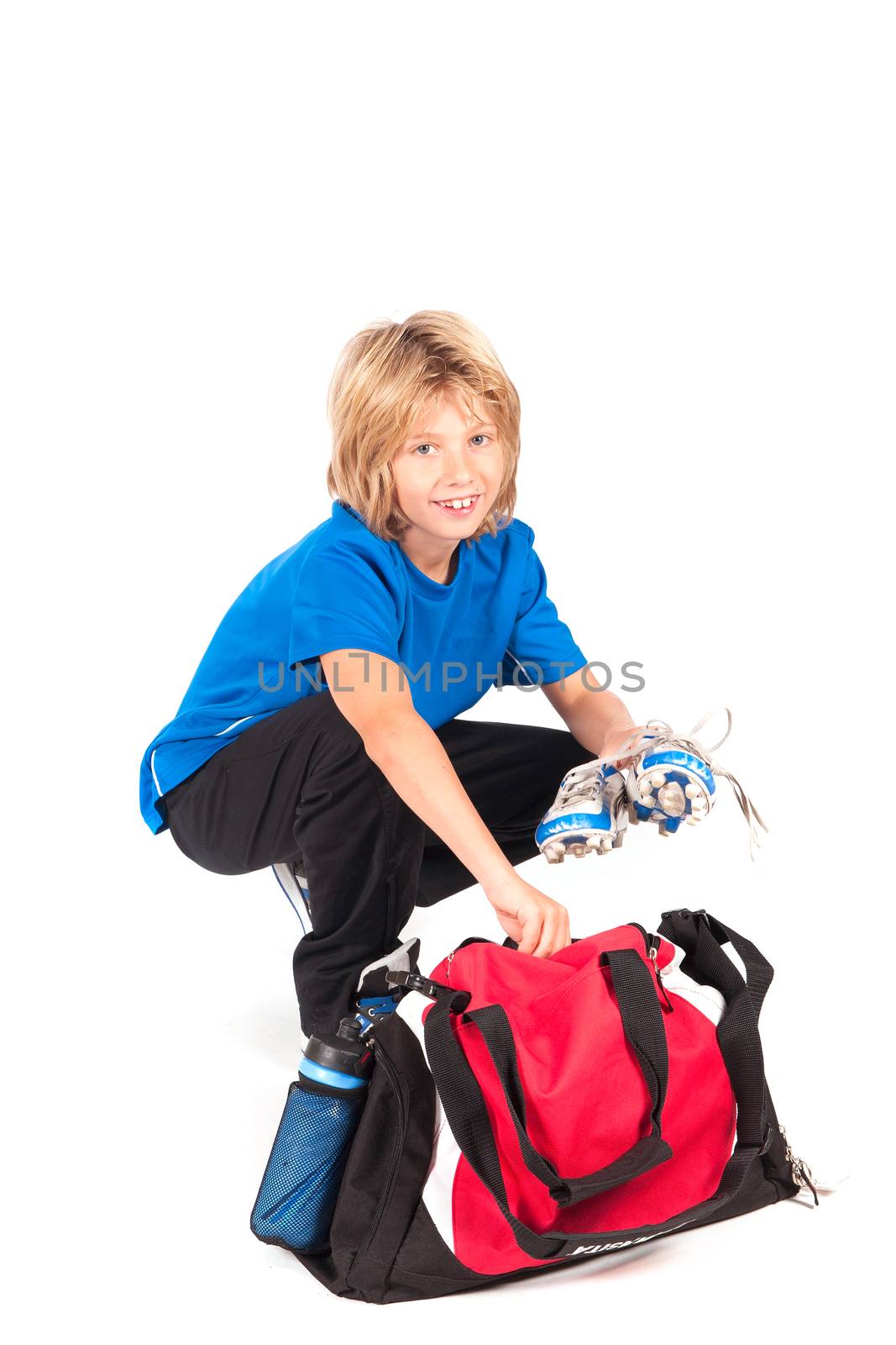 a young boy, ready for putting on his football shoes and play football