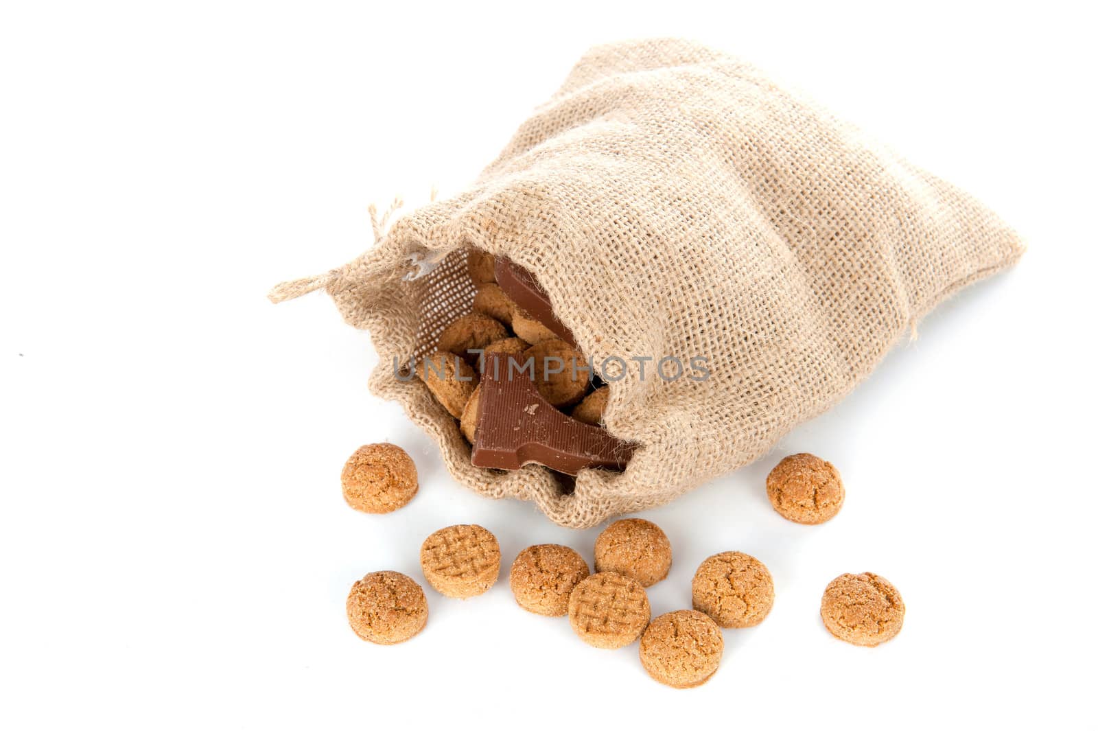 A jute bag full of pepernoten and a chocolate letter, for celebrating a dutch holiday " Sinterklaas "  on the fifth of December