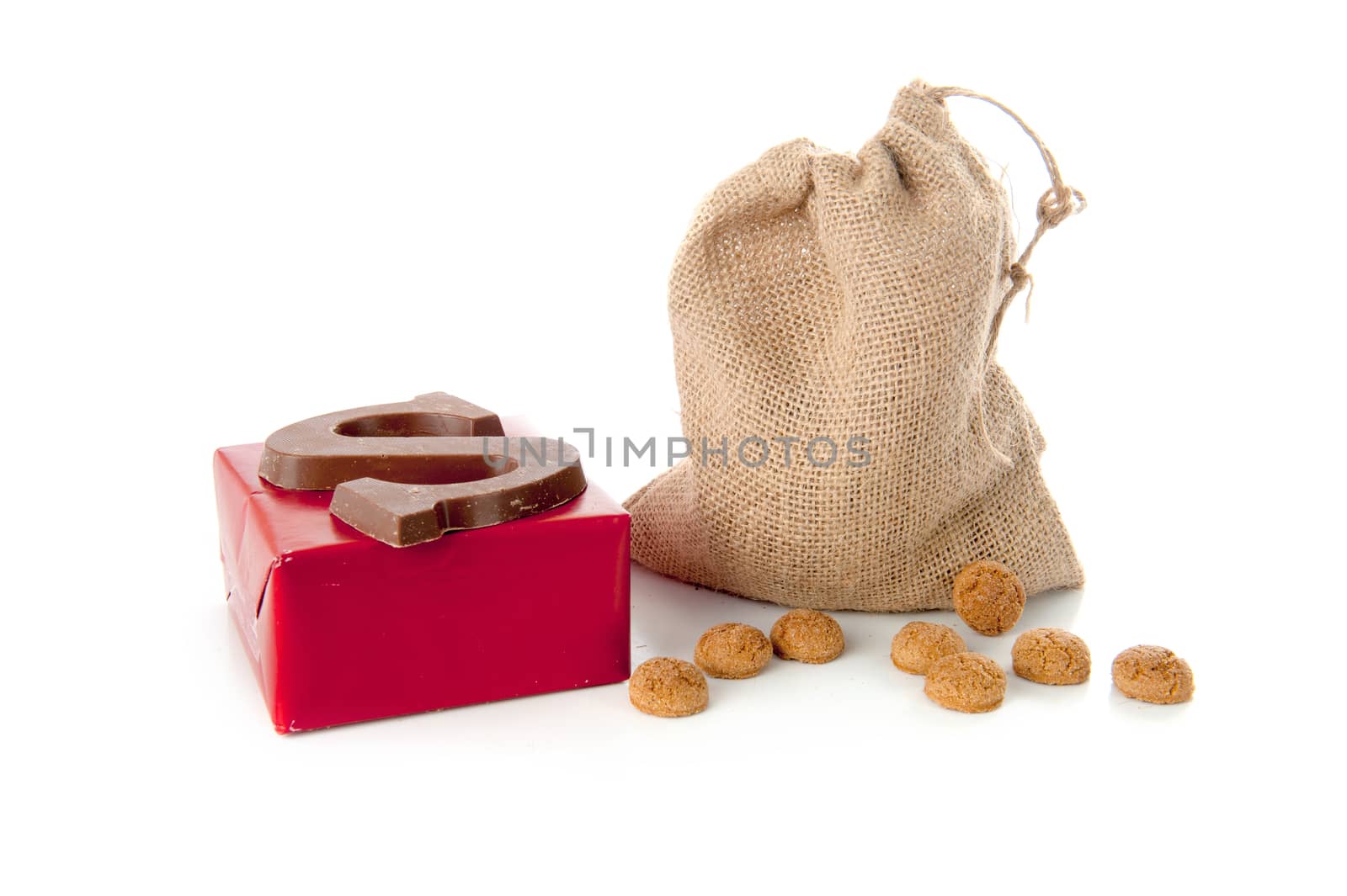 A jute bag full of pepernoten, a present and a chocolate letter, for celebrating a dutch holiday " Sinterklaas "  on the fifth of December