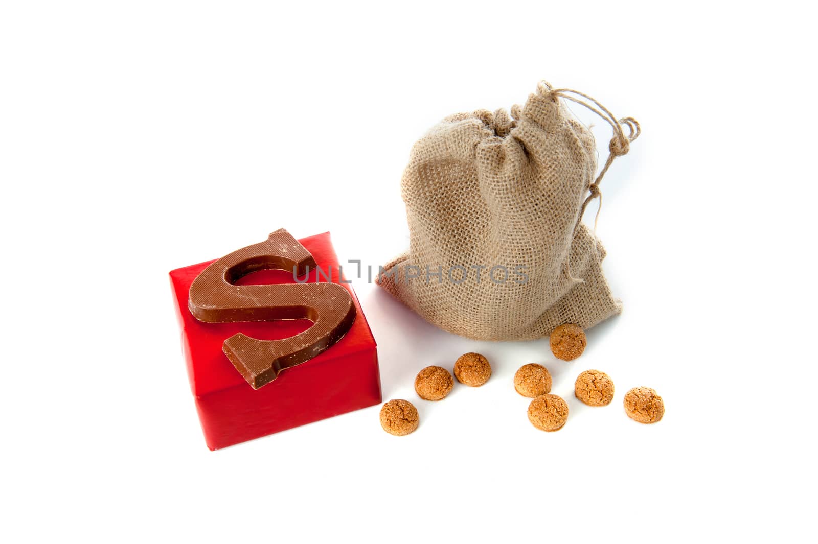 A jute bag full of pepernoten, a present and a chocolate letter, for celebrating a dutch holiday " Sinterklaas "  on the fifth of December