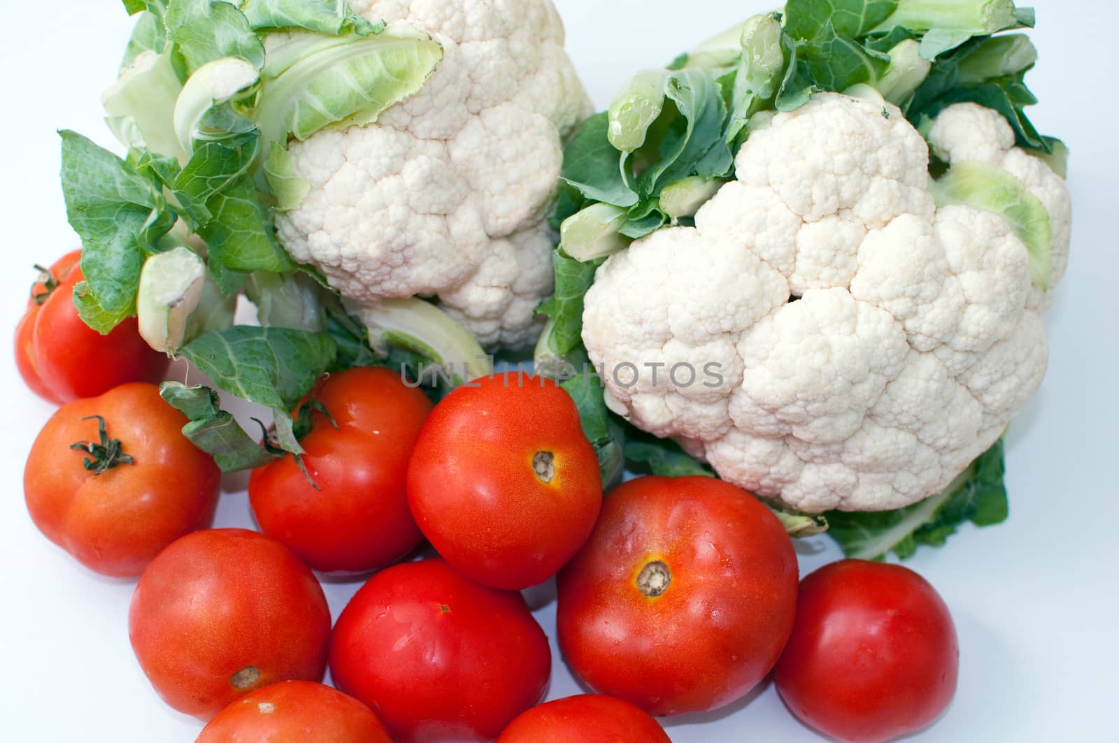 Freshly cut  cauliflower cabbage  and tomatoes isolated on white .