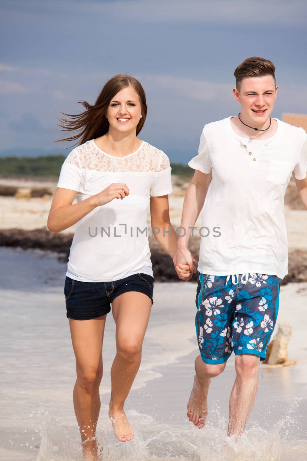 happy young couple on the beach in summer holiday love togetherness