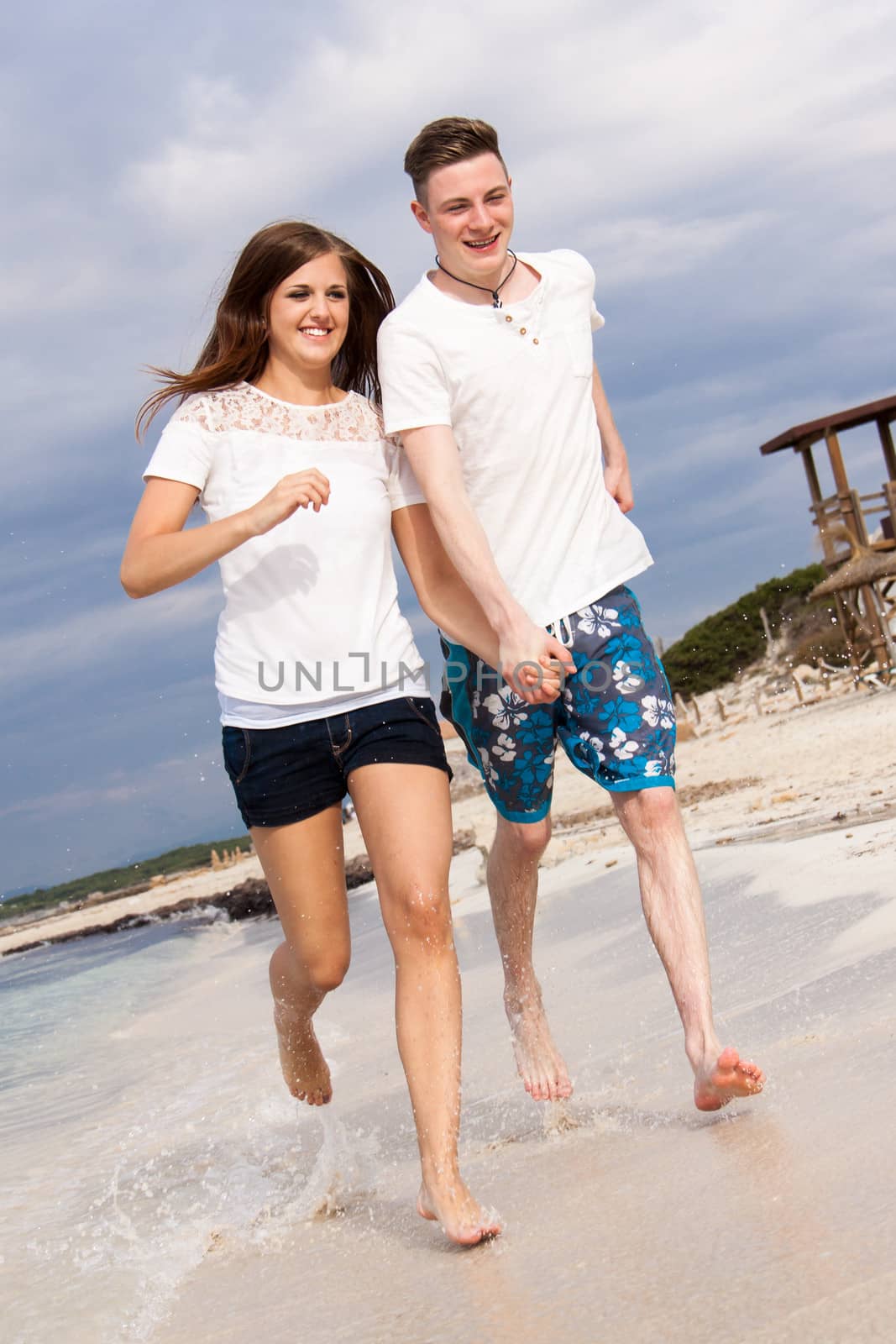 happy young couple on the beach in summer holiday love togetherness