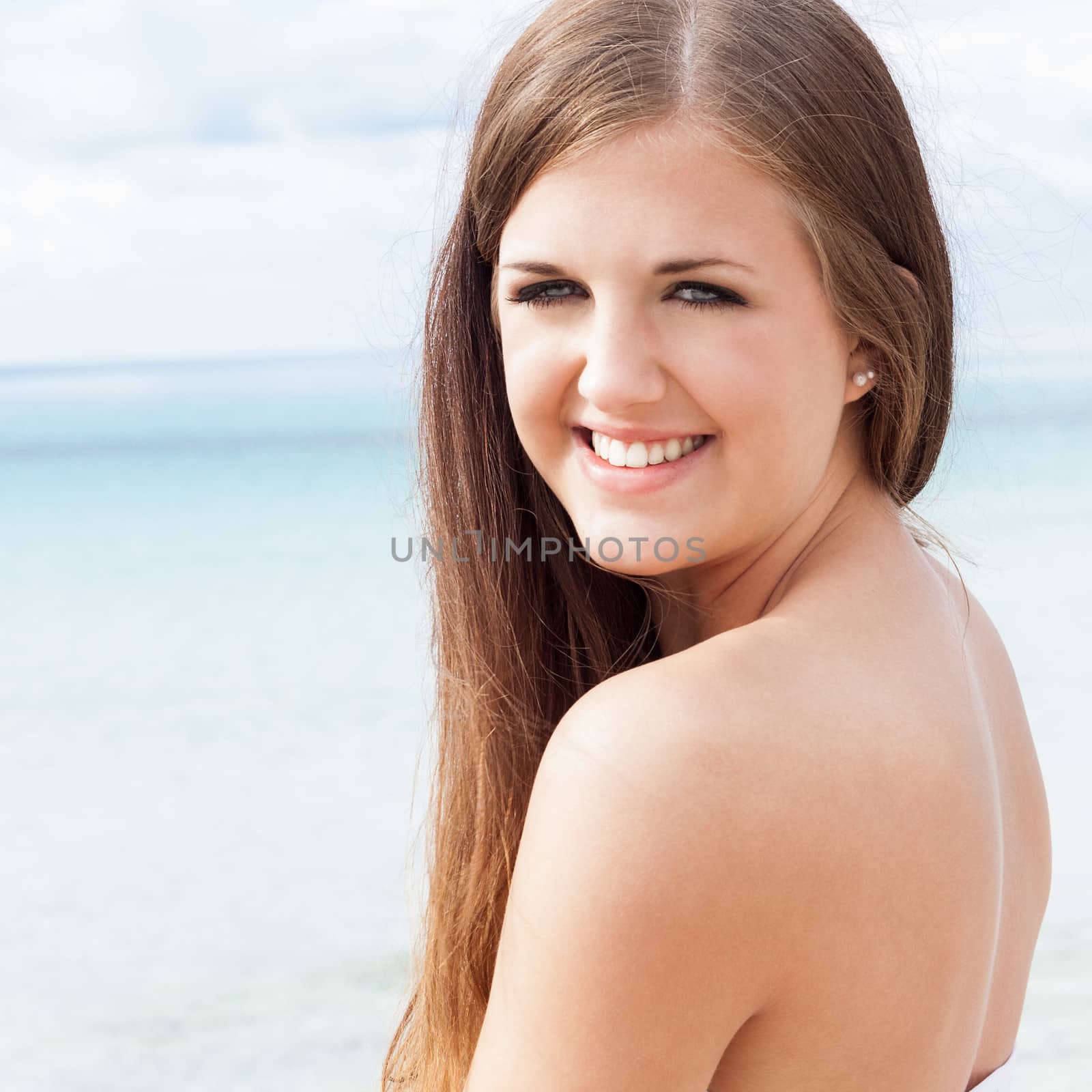 smiling young brunette woman in summer on the beach  by juniart