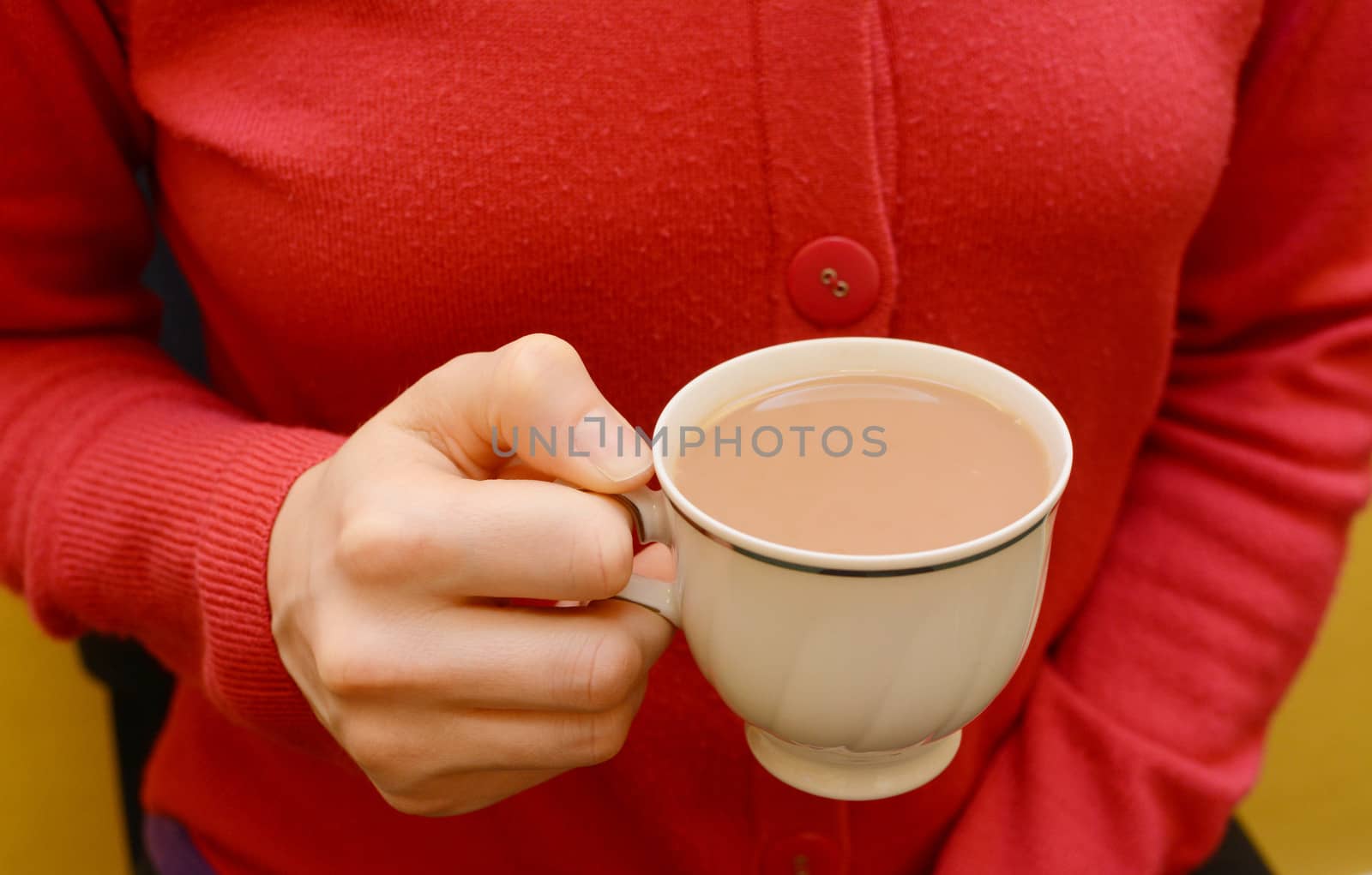 Teacup of white tea in a woman's hand