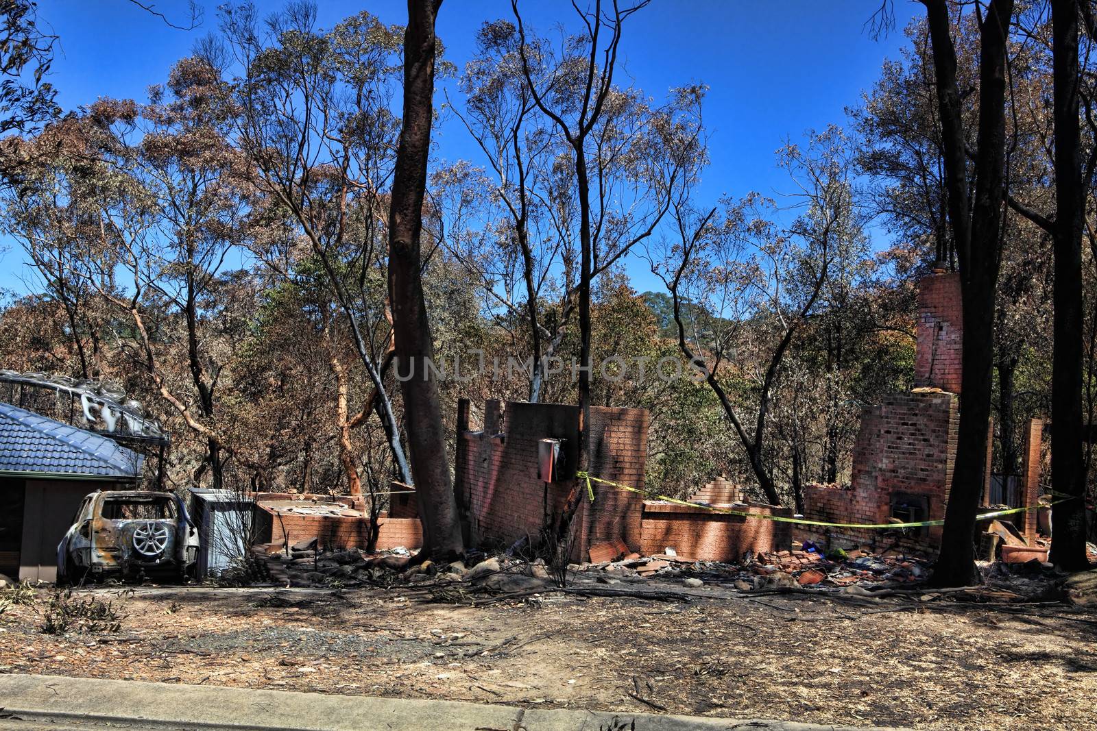 After the fire.   Bushfire destroys homes and vehicles in a random pattern while some are spared completely, others are razed to the ground.