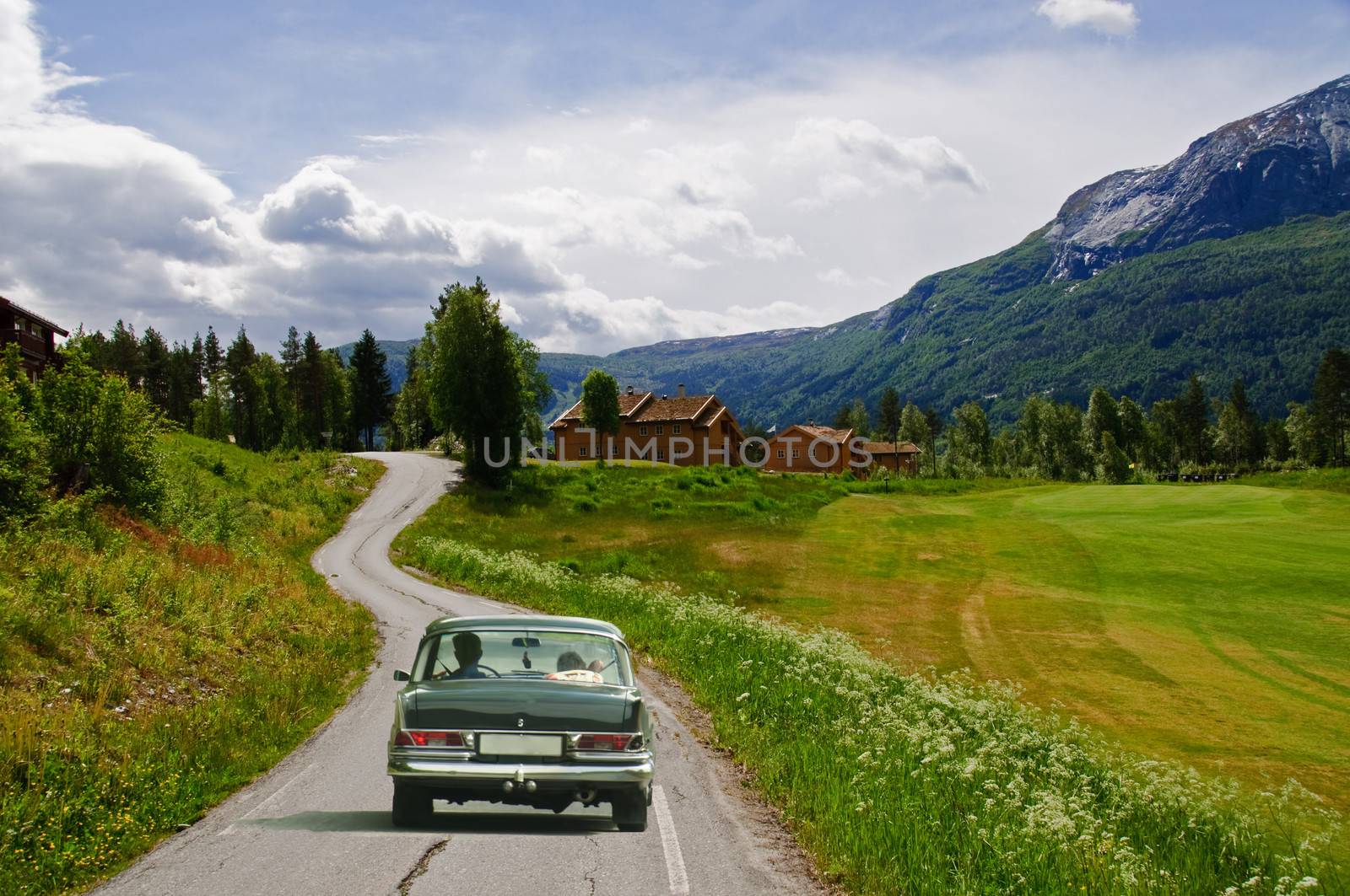 A country road in the mountains and a veteran car