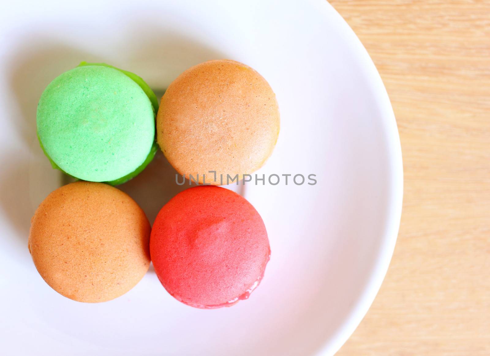 Tasty colorful macaroons on wooden background