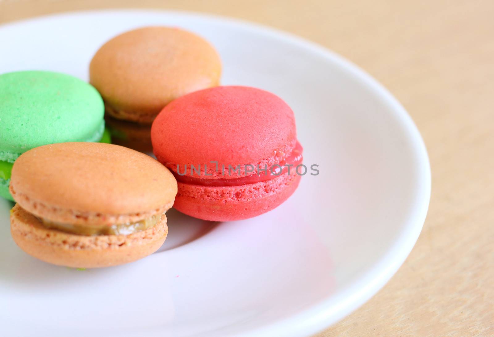 Tasty colorful macaroons on wooden background