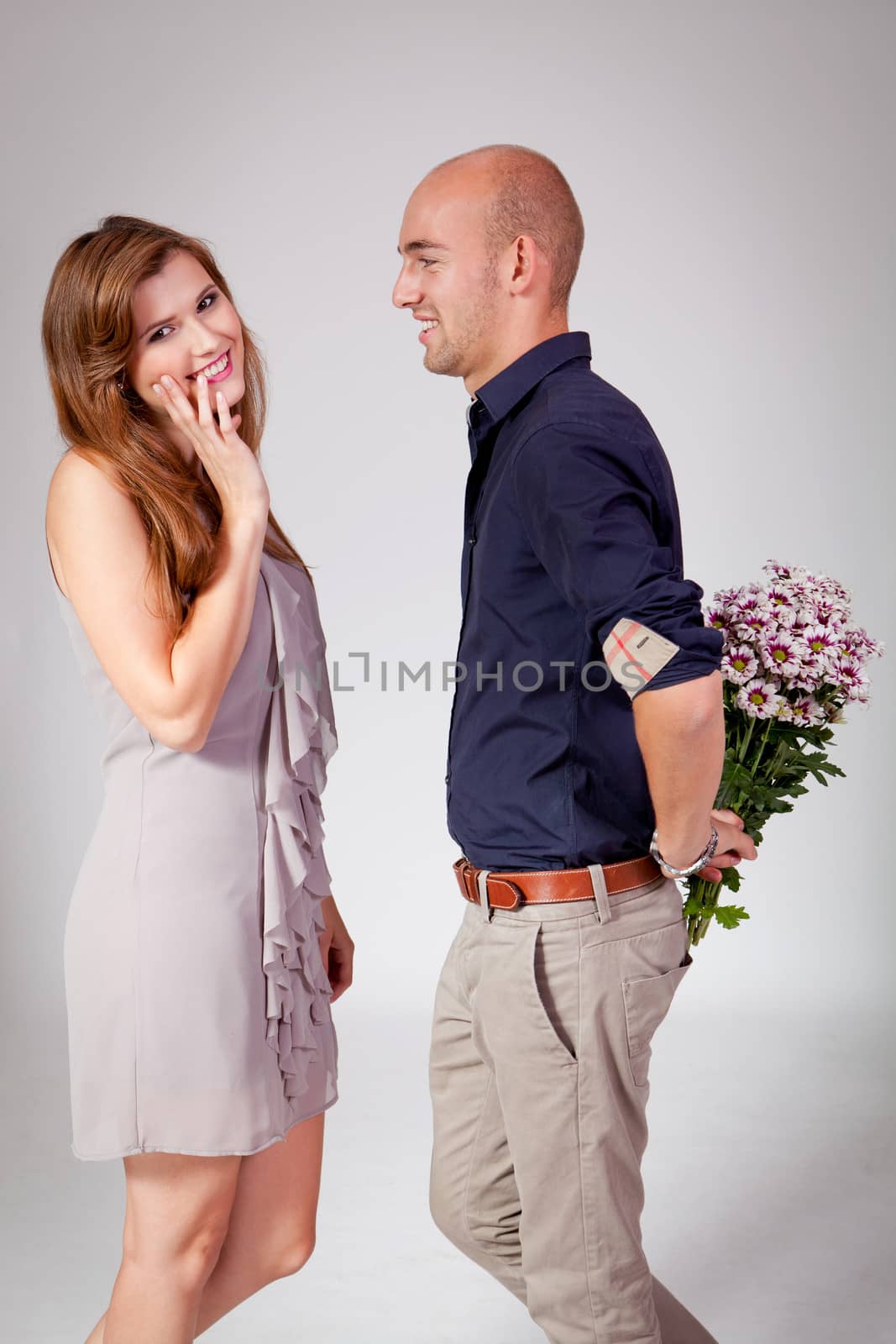 young attractive couple in love embracing portrait on grey backgound 