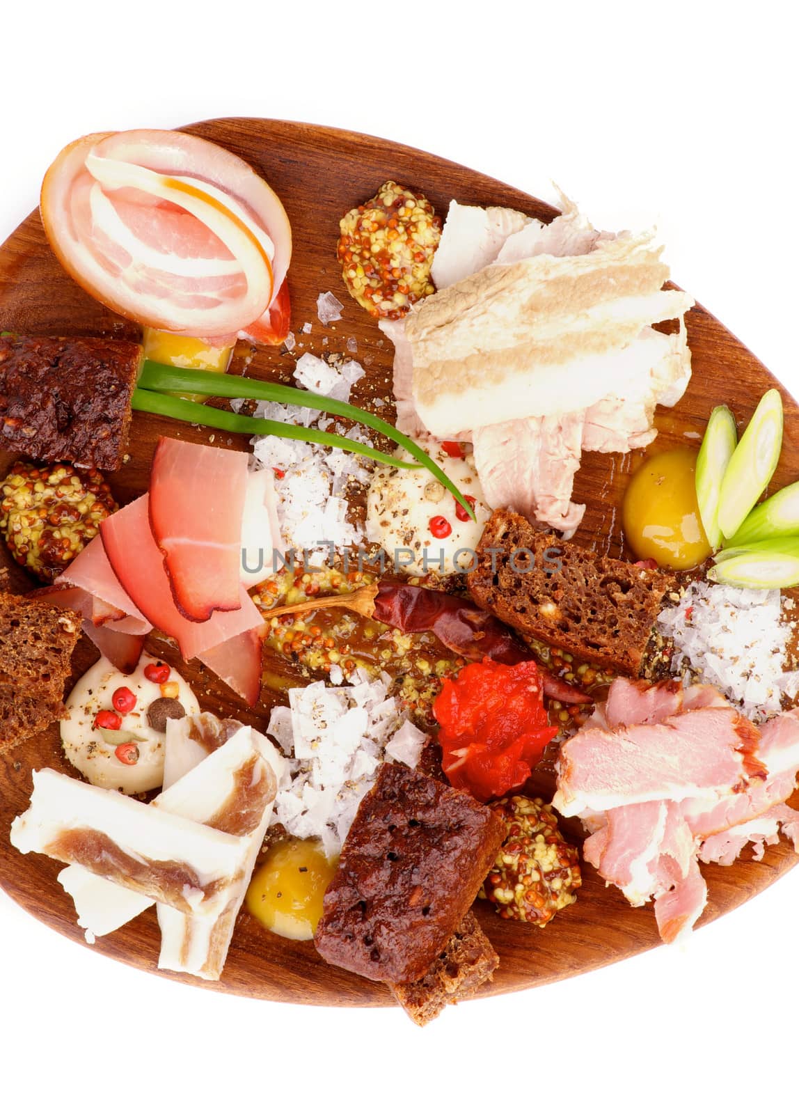 Arrangement of Various Smoked, Boiled and Uncooked Ham with Mustard, Salt, Brown Bread and Spices on Wooden Plate isolated on white background