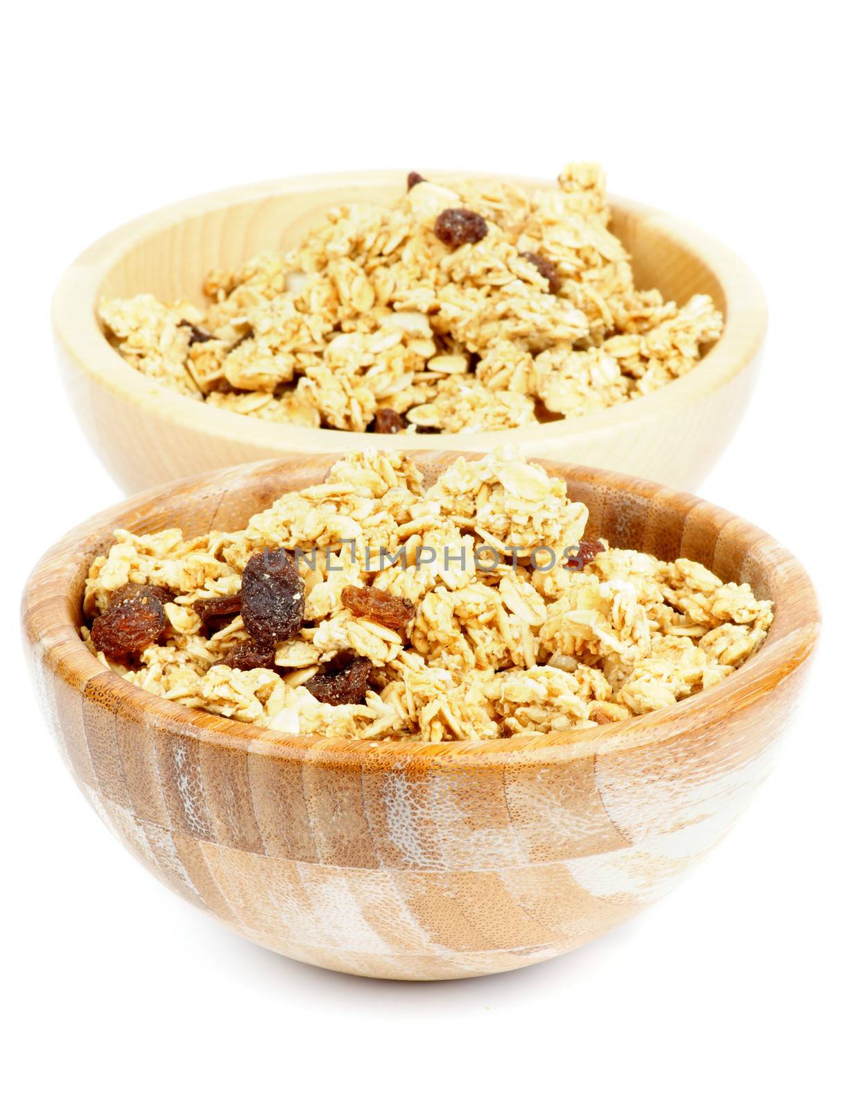 Breakfast Cereal Flakes with Slices of Nuts and Raisins in Two Wooden Bowls isolated on white background