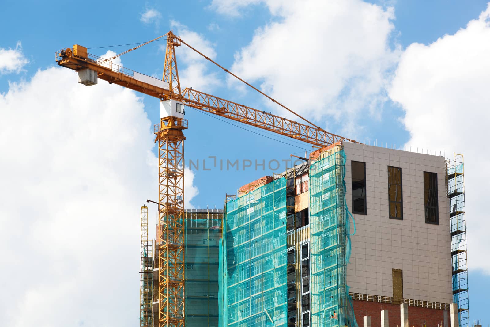 Crane and construction site against blue sky.