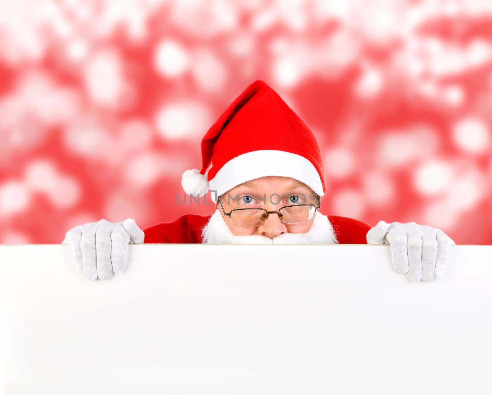 Frightened Santa Claus behind the White Board on the Abstract Winter Background