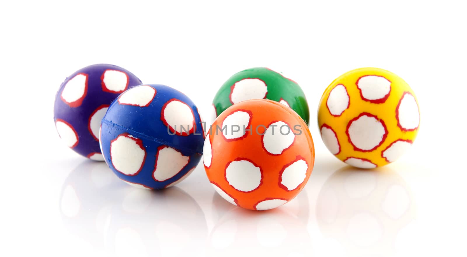 Five colorful balls in closeup over white background