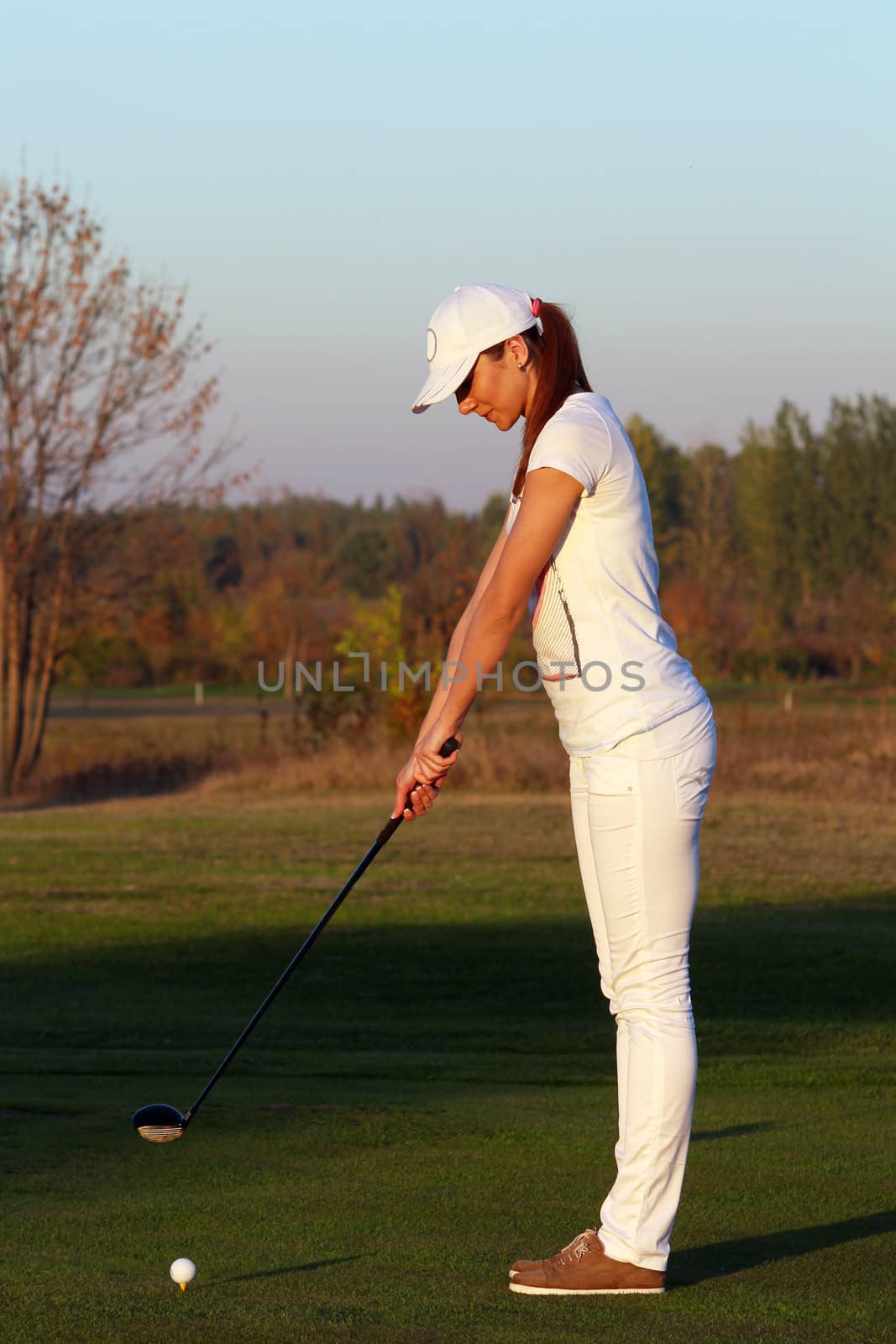 girl golf player preparing for shot by goce