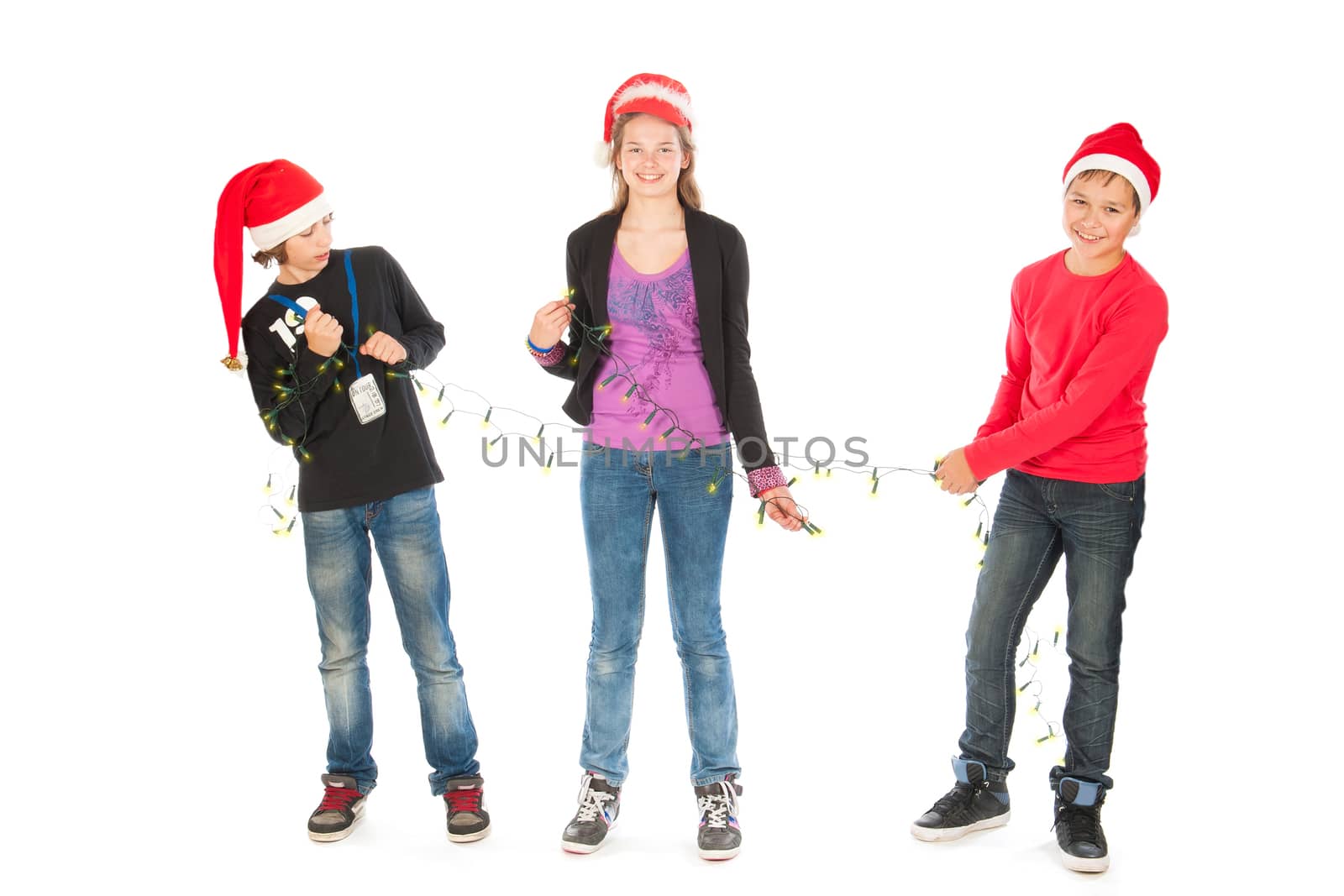 two boys decorating a girl for Christmas, on a white background