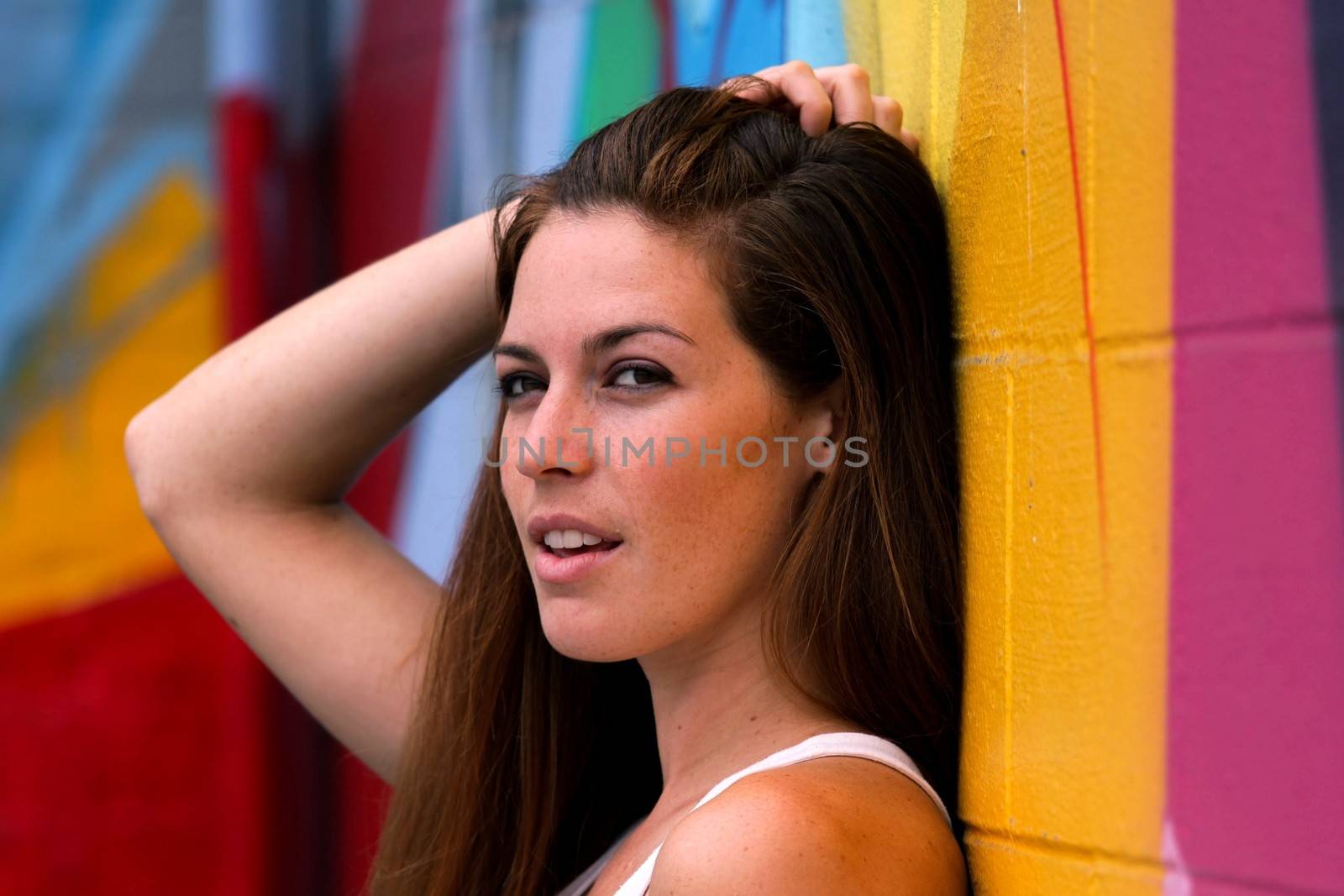 Portrait Of A WomanSide view portrait of a woman with colorful wall in the background.