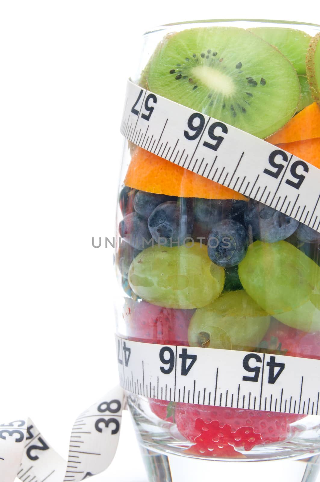 Five fruits packed into a glass including kiwi, berries and orange 