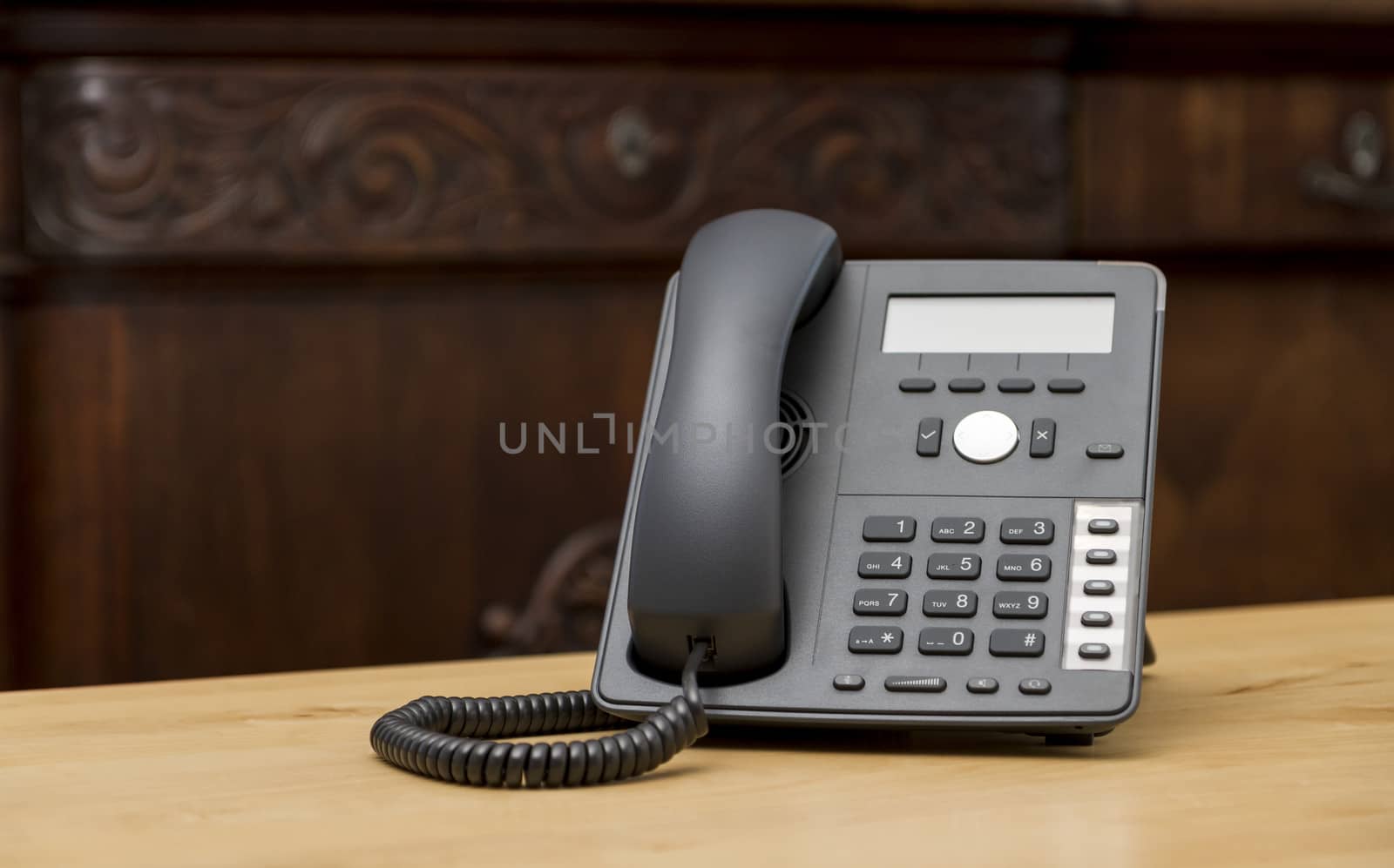 modern phone on wooden table in living room with old commode