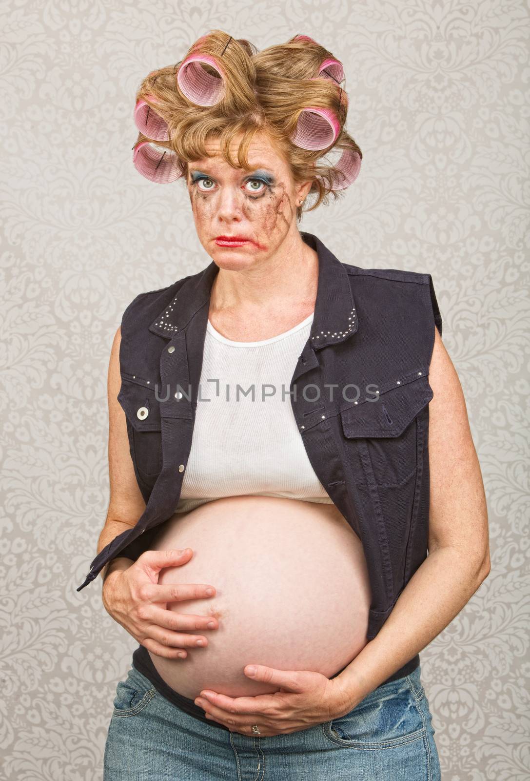 Suspicious pregnant woman in curlers and makeup