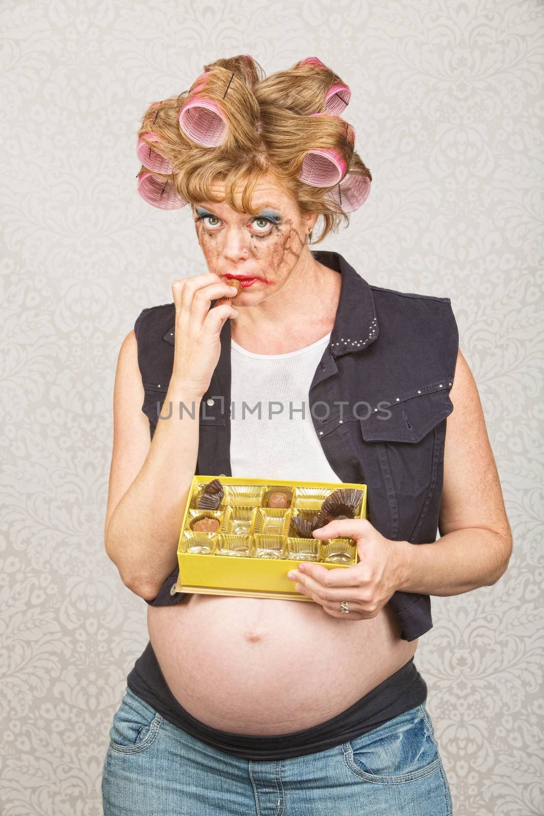 Expectant hillbilly in curlers eating box of chocolates