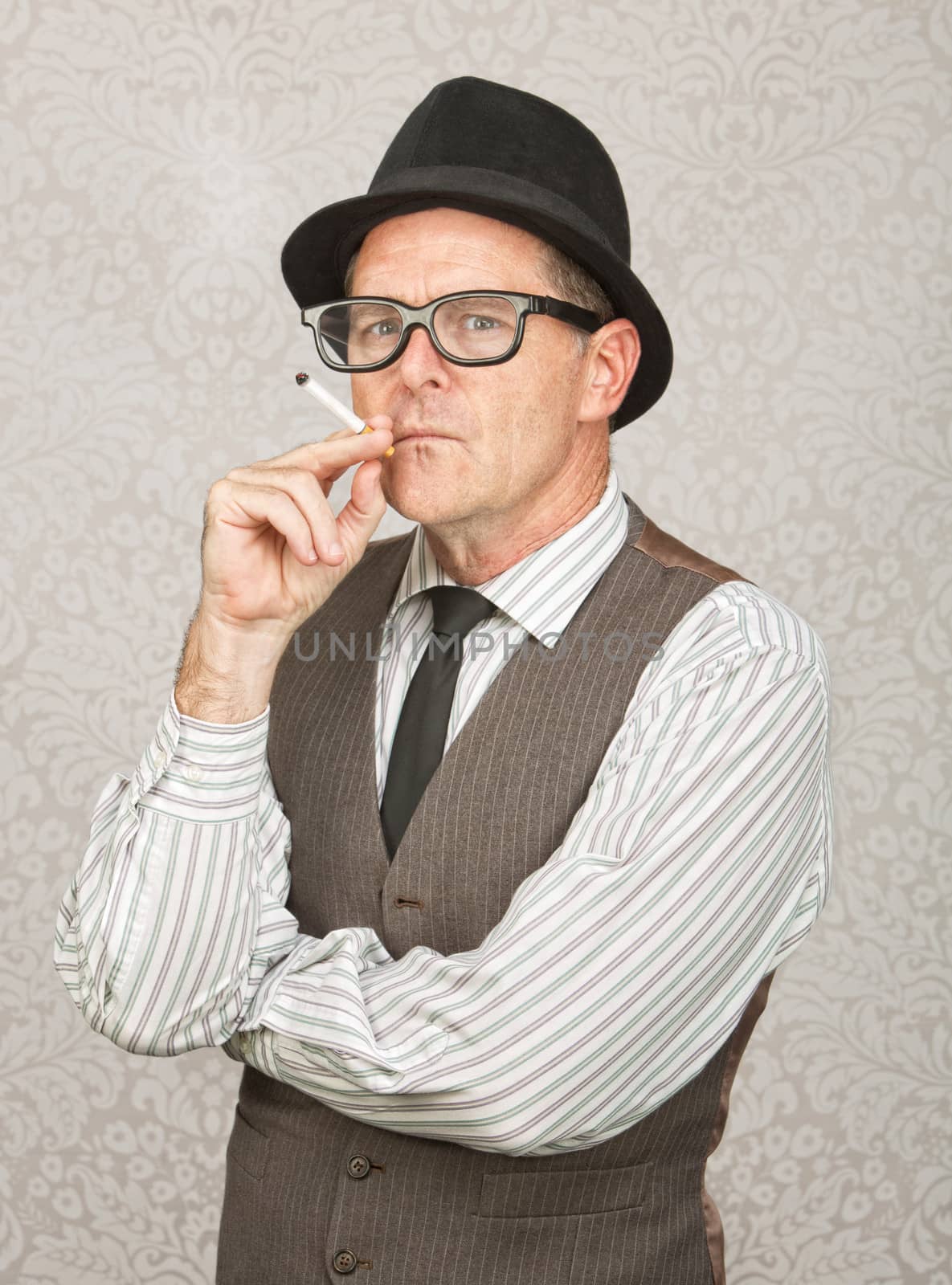 Skeptical white businessman with hat smoking a cigarette