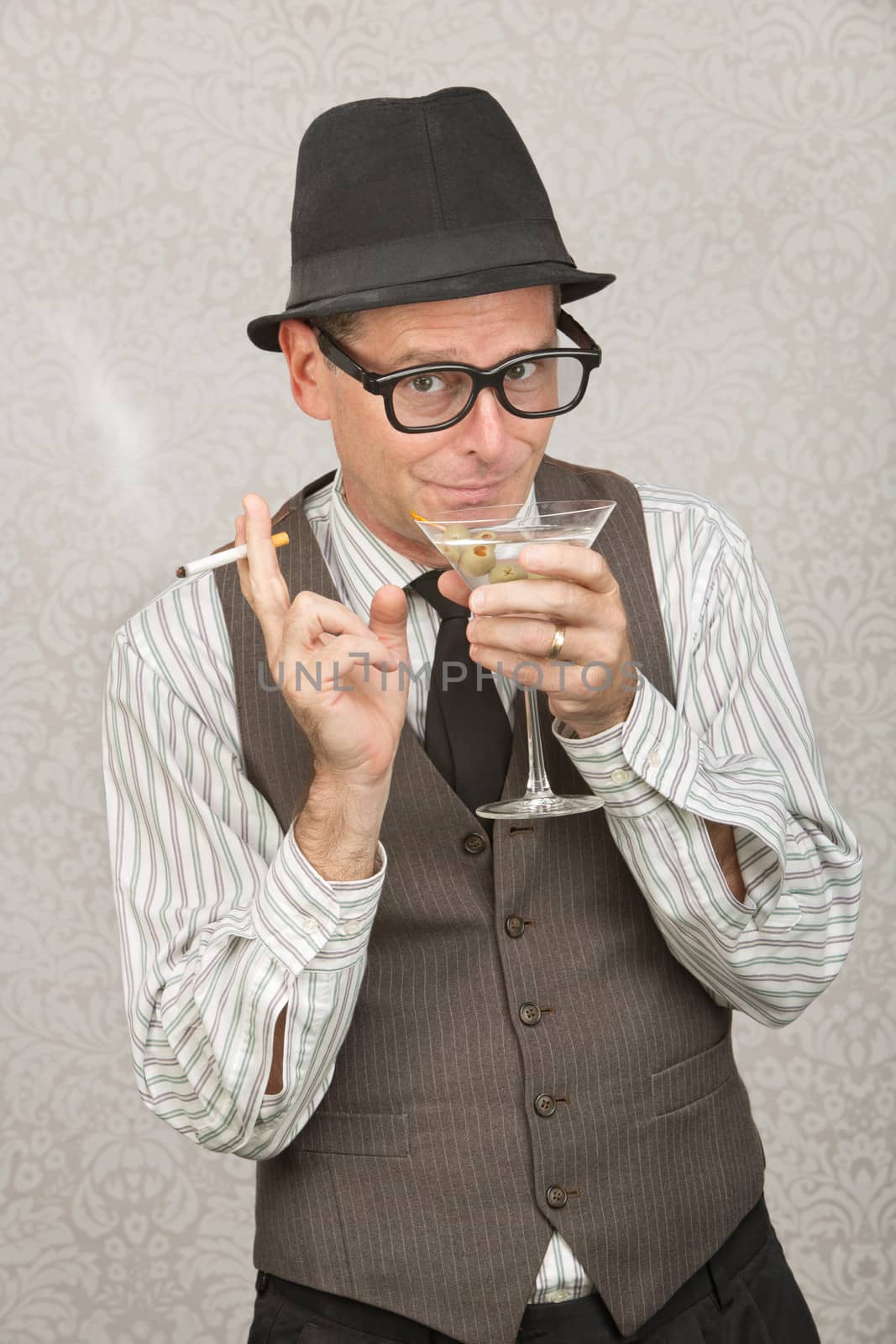 Smirking businessman with hat and eyeglasses drinking alcohol