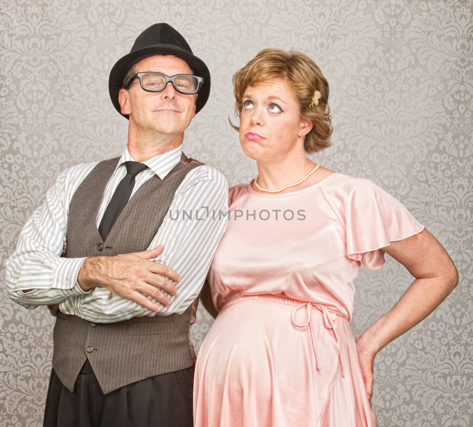 Proud 1950s man with bored pregnant woman