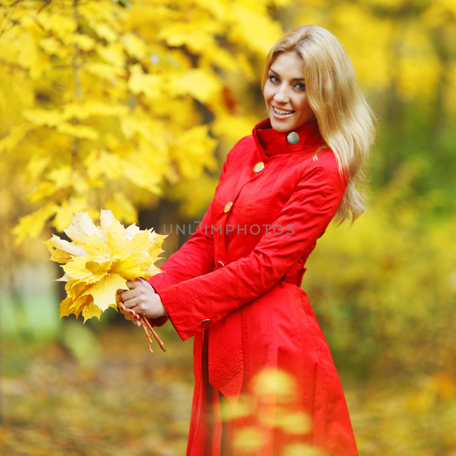 Young woman holding a bunch of autumn leaves