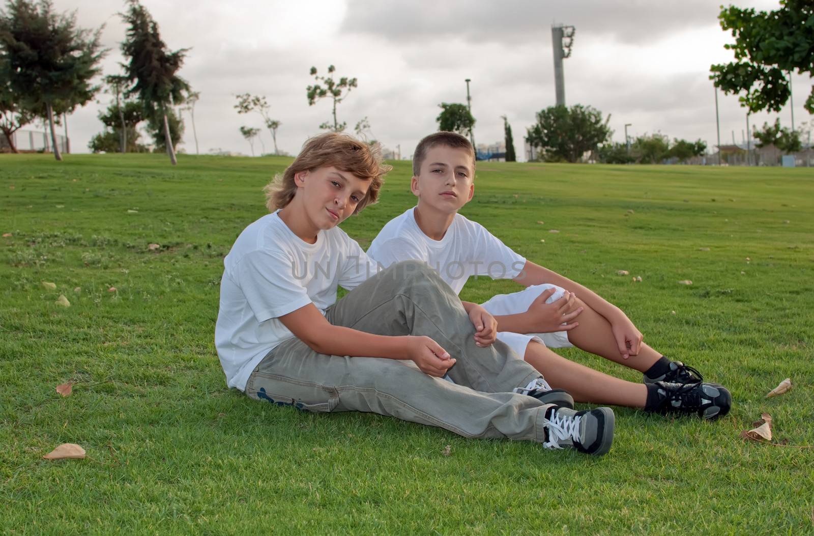Portrait of two boys on the grass in the park  .