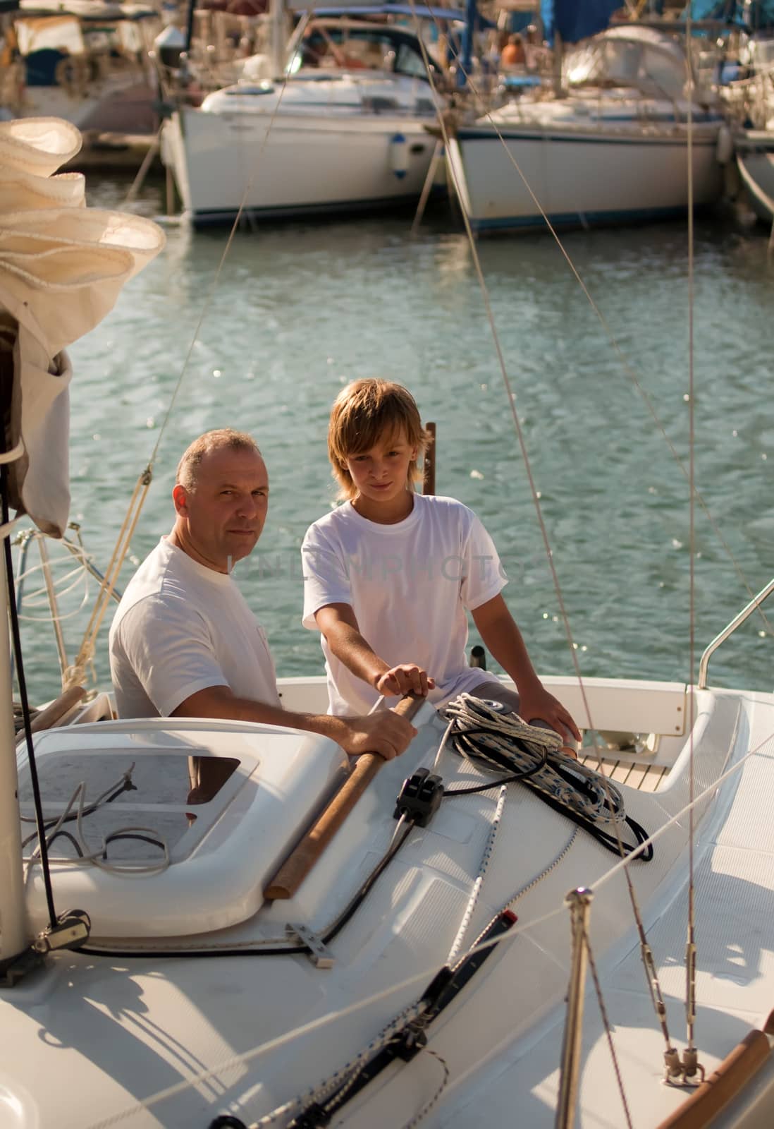 Dad and son on a yacht. by LarisaP