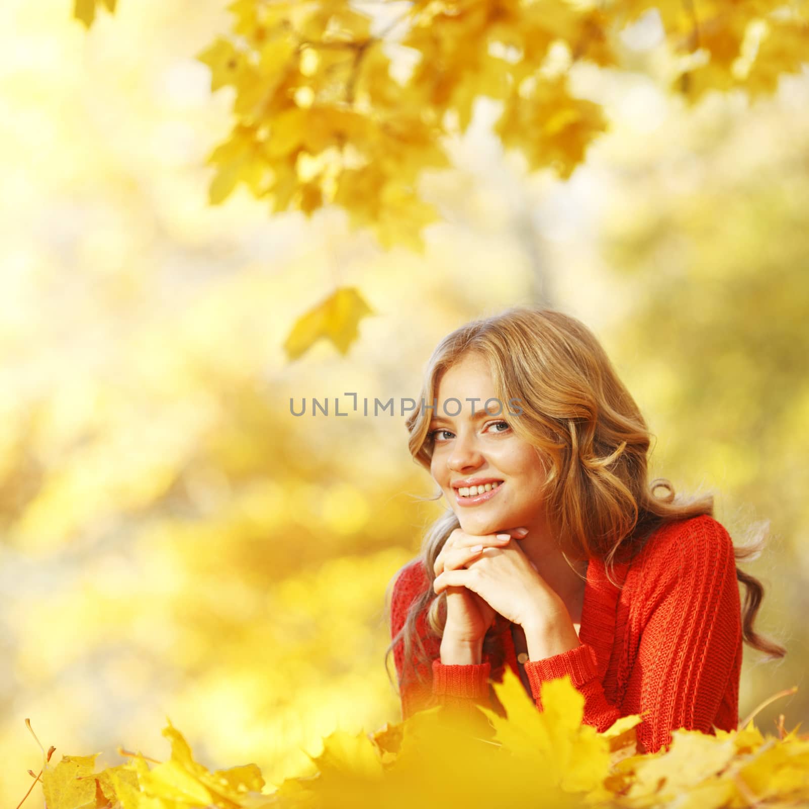 Woman laying on autumn leaves by Yellowj