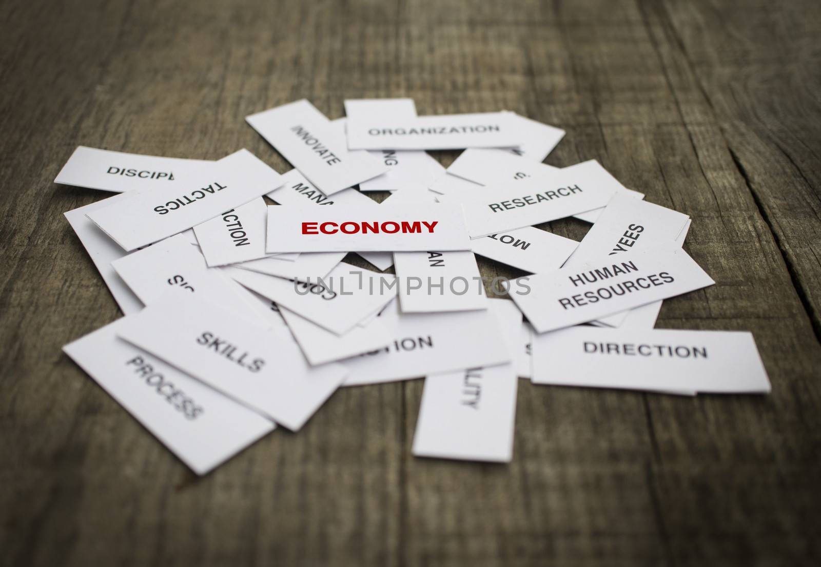 Paper strips with Economy related words on wooden background