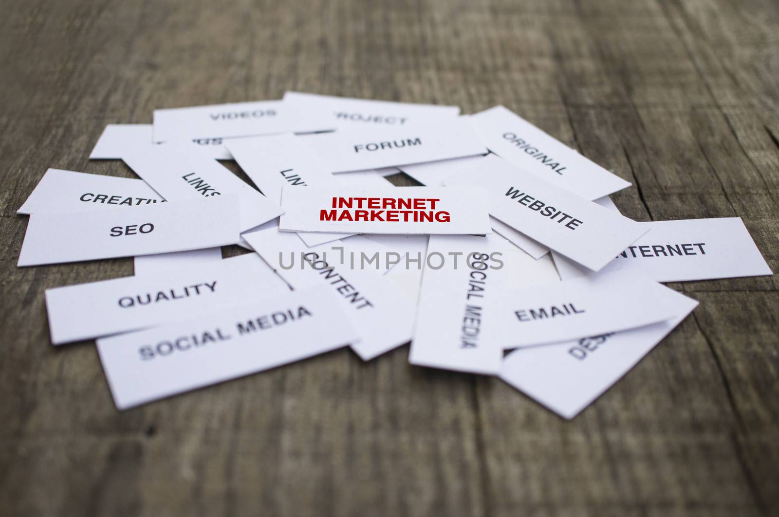 Paper strips with Internet Marketing related words on wooden background