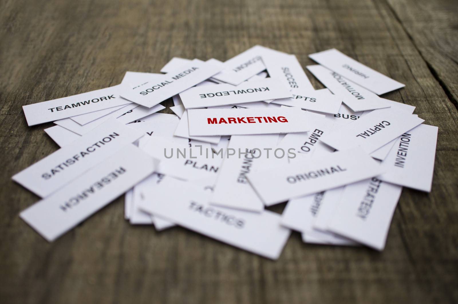 Paper strips with Marketing related words on wooden background