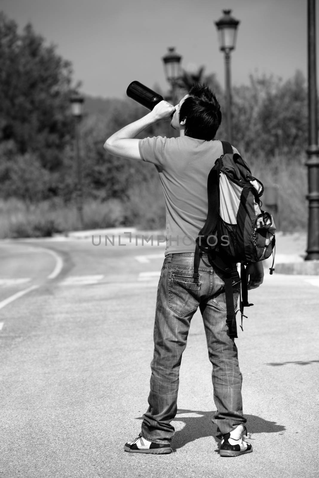 Drunkard walking around the streets boozing from a bottle