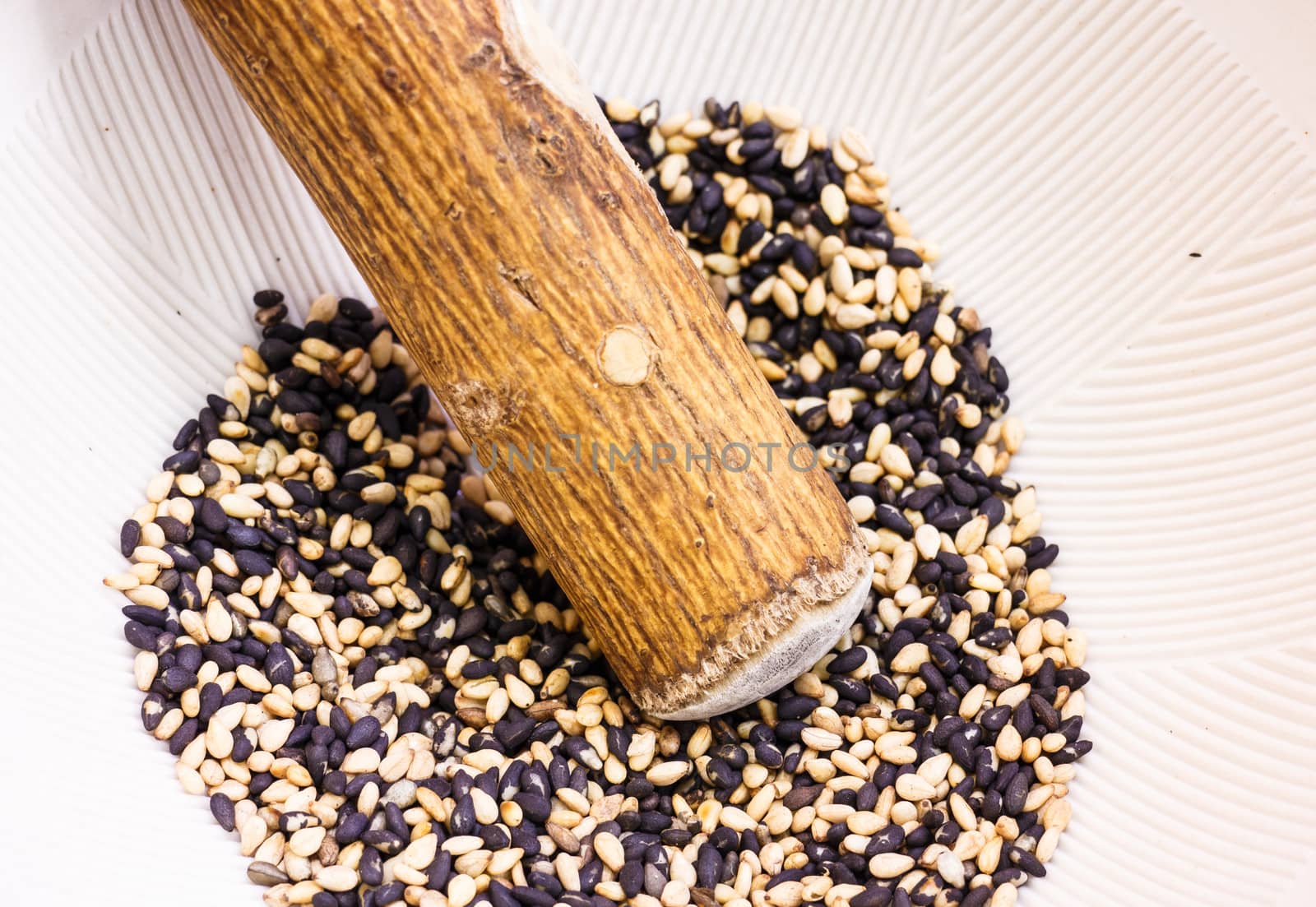 Sesame in a bowl with wooden pestle