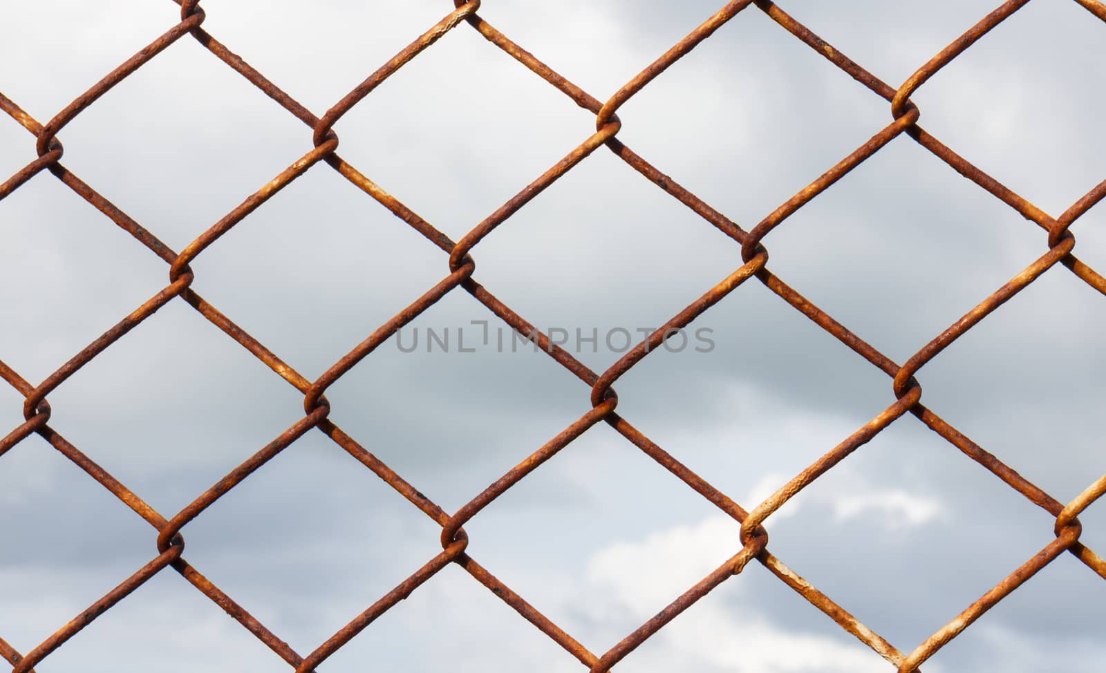 Wire Mesh Fence on storm clouds background