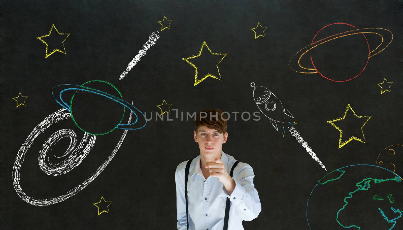 Businessman pointing at chalk universe planet solar system on blackboard imagining space travel by alistaircotton