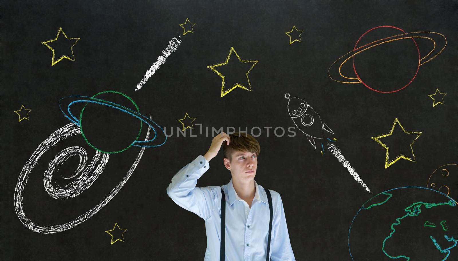 Businessman scratching head with chalk universe planet solar system on blackboard imagining space travel